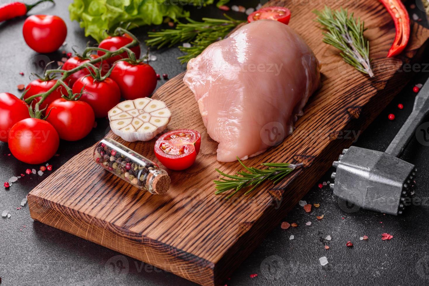 Fresh raw chicken fillet and vegetables prepared for cooking photo