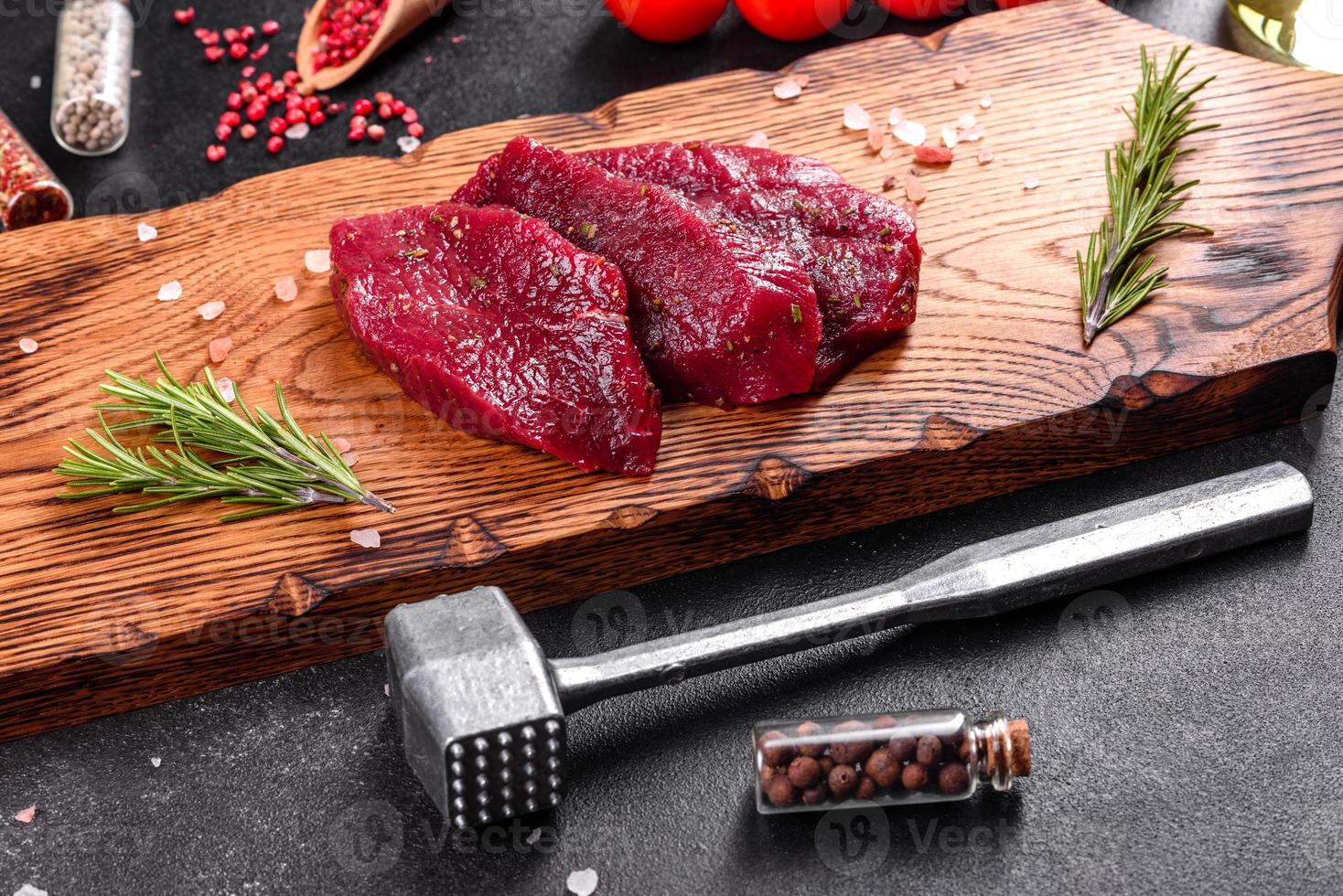 Fresh Raw Beef steak Mignon, with salt, peppercorns, thyme, tomatoes photo