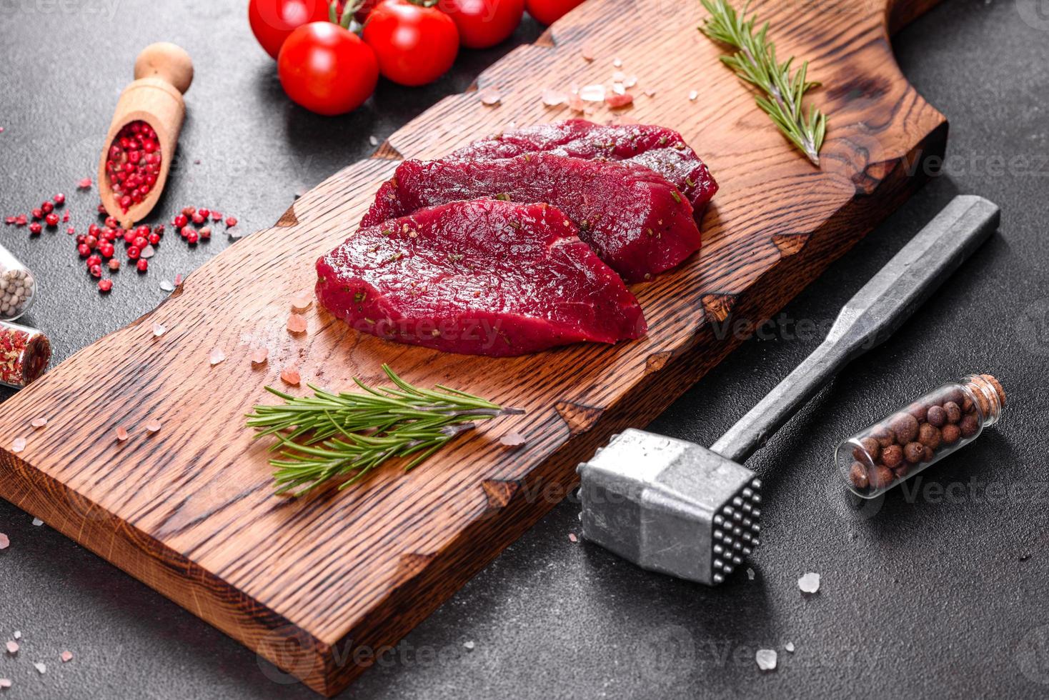 Fresh Raw Beef steak Mignon, with salt, peppercorns, thyme, tomatoes photo