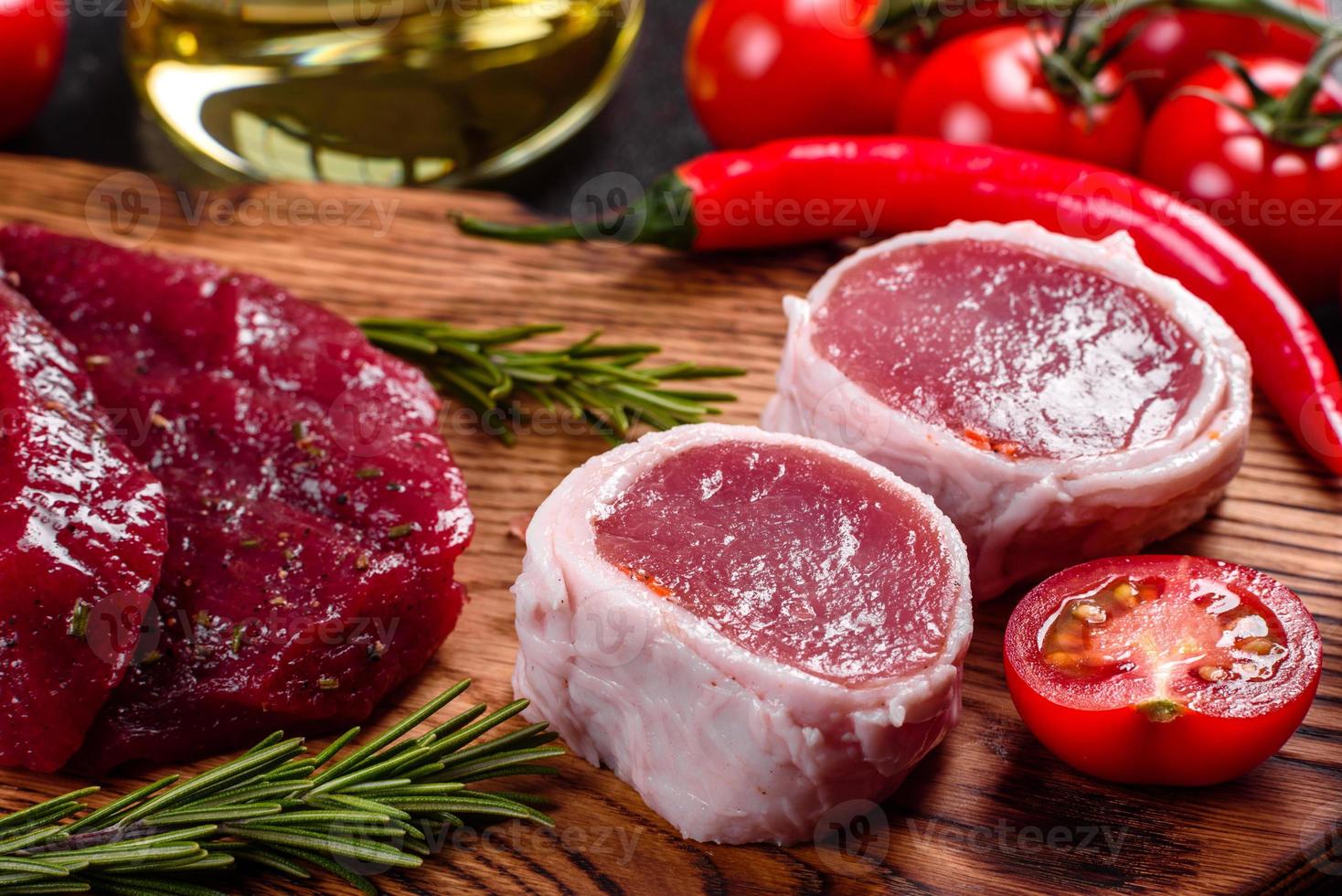 Fresh Raw Beef steak Mignon, with salt, peppercorns, thyme, tomatoes photo