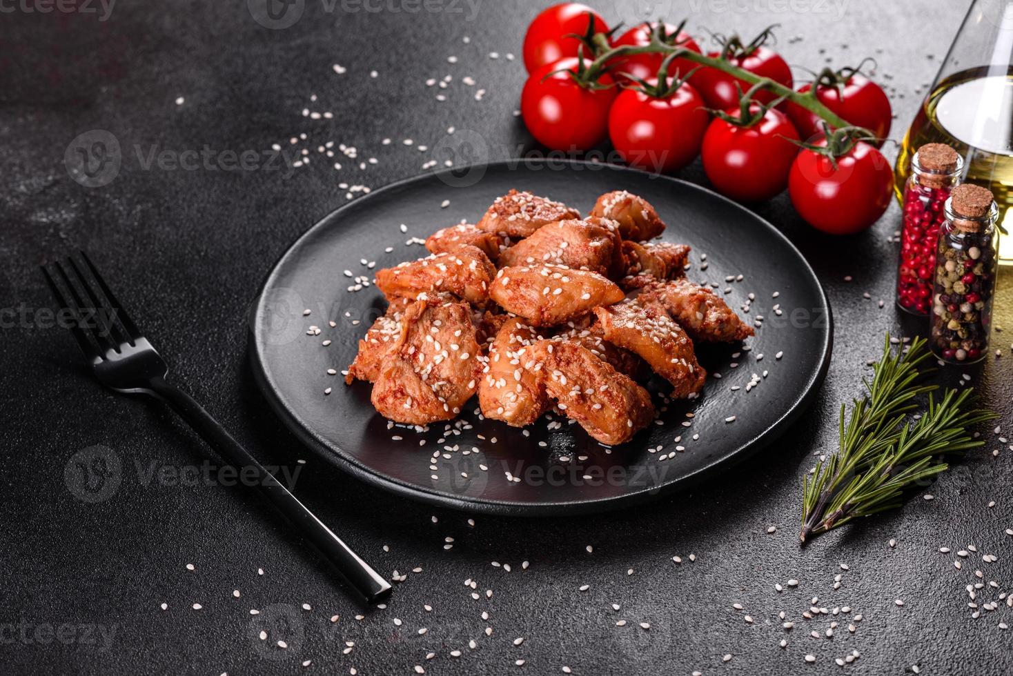 Chicken fillet in sesame seeds, teriyaki sauce on a black stone plate photo