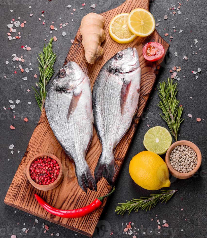 Raw dorado fish with spices cooking on cutting board photo