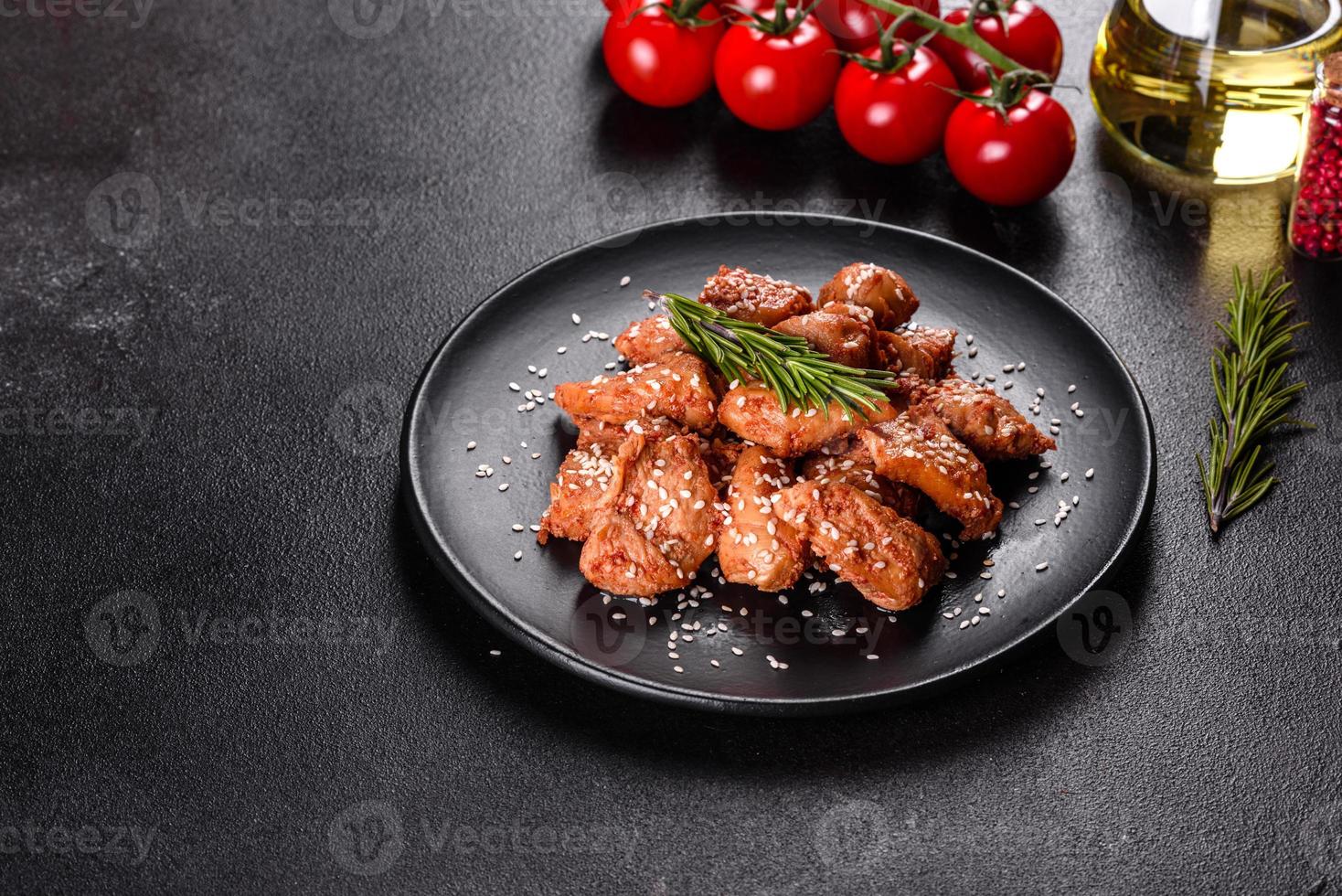 Chicken fillet in sesame seeds, teriyaki sauce on a black stone plate photo