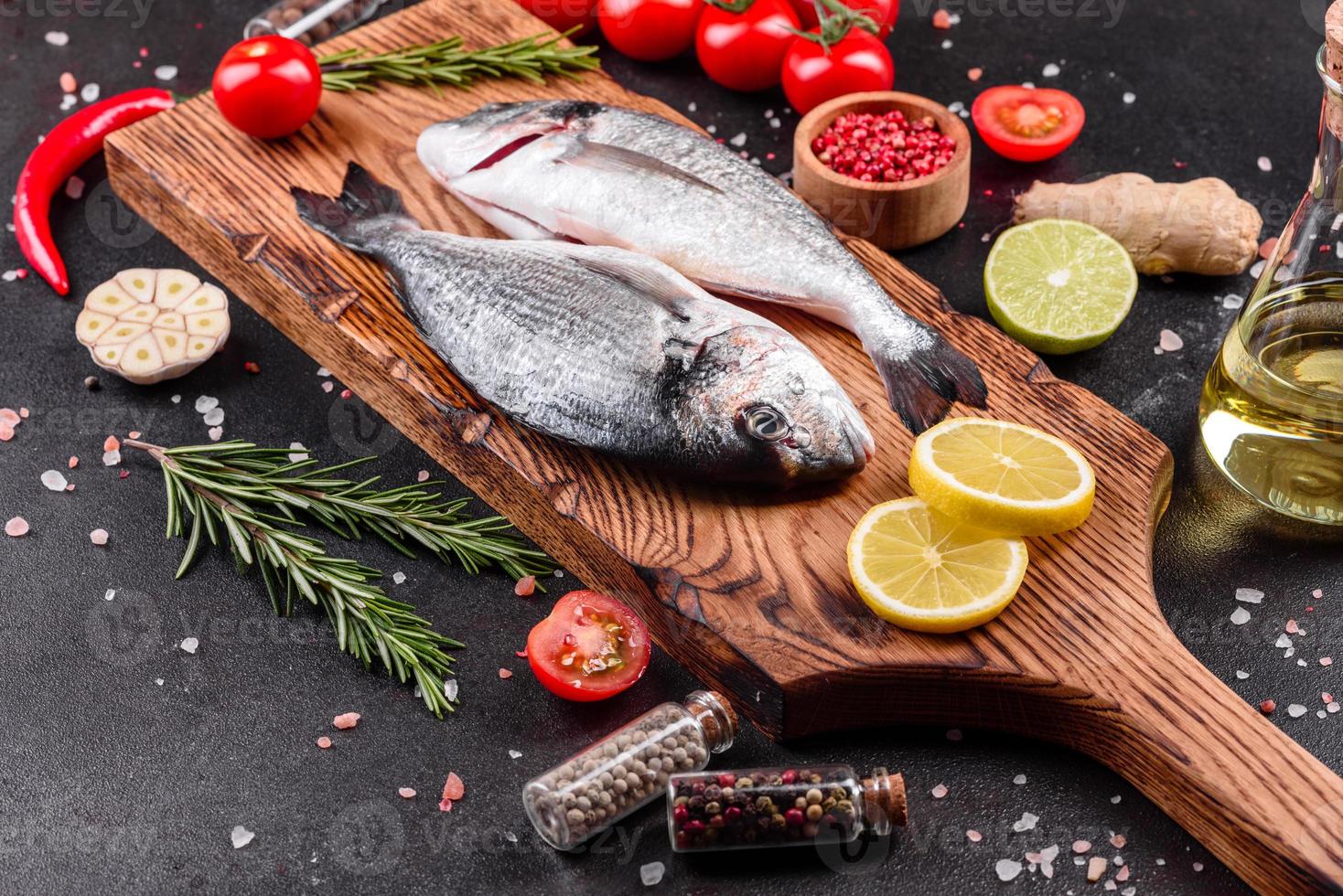 Raw dorado fish with spices cooking on cutting board photo