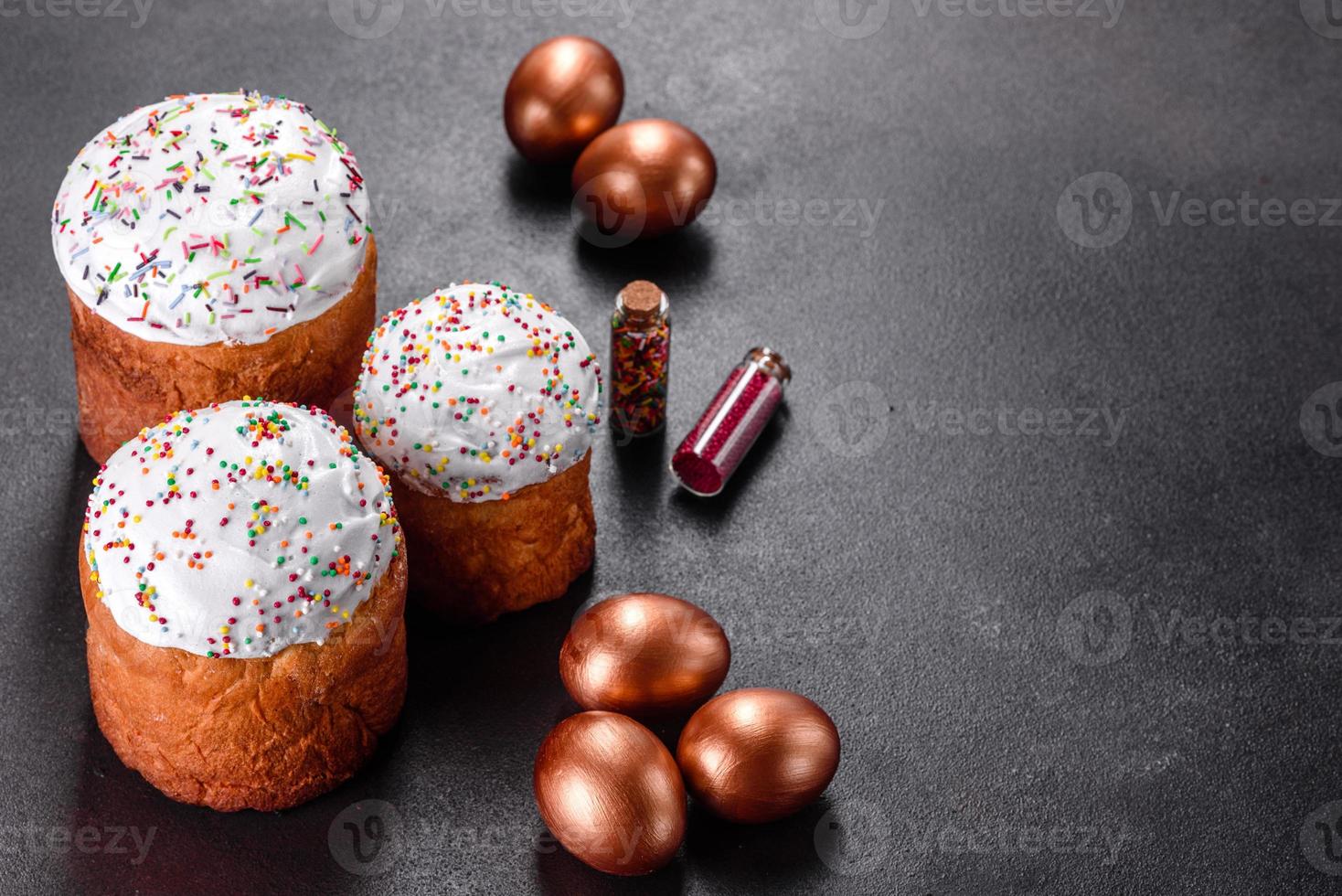 Huevos de pascua de oro y bronce y pastel de pascua sobre un fondo oscuro foto