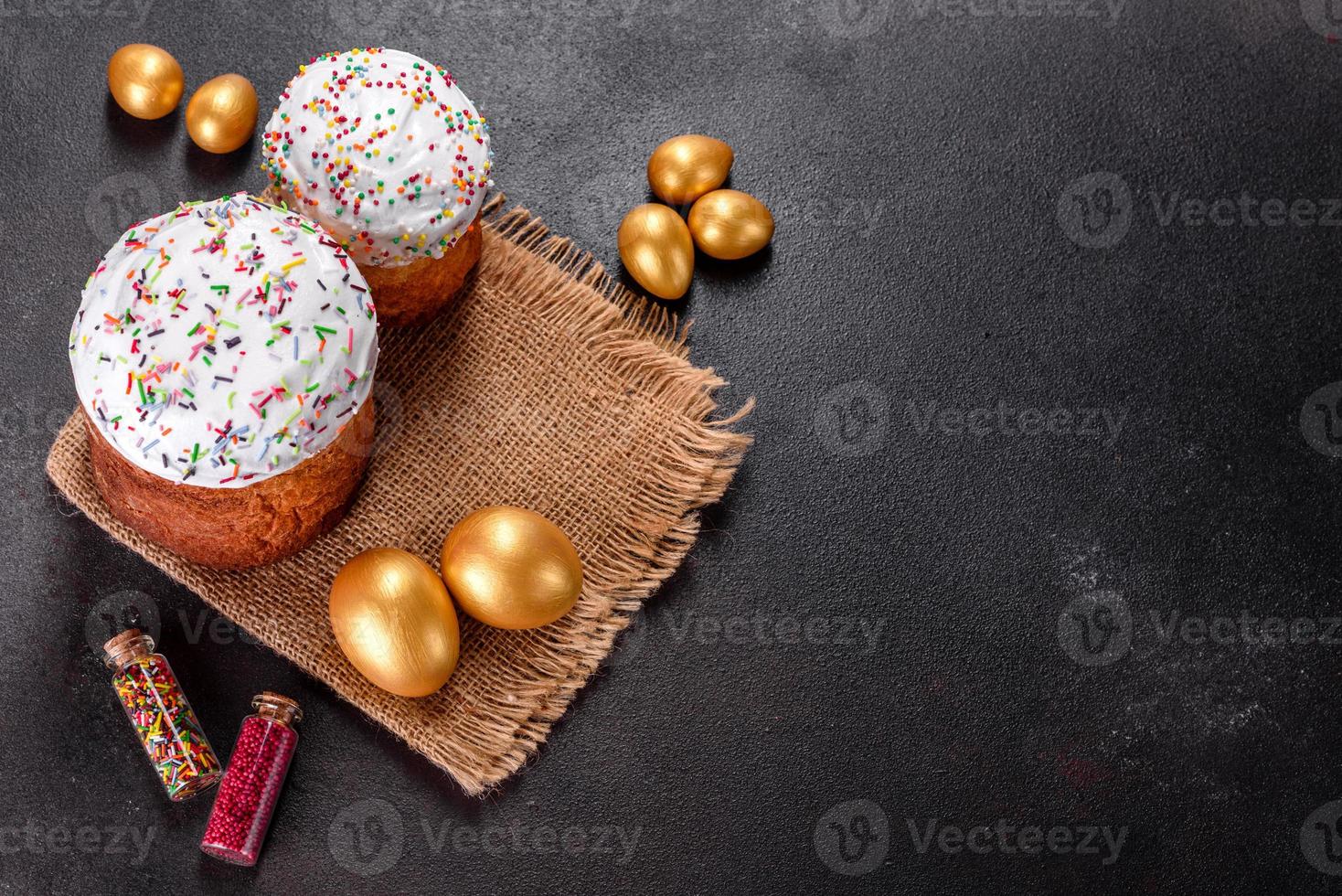 Huevos de pascua de oro y bronce y pastel de pascua sobre un fondo oscuro foto