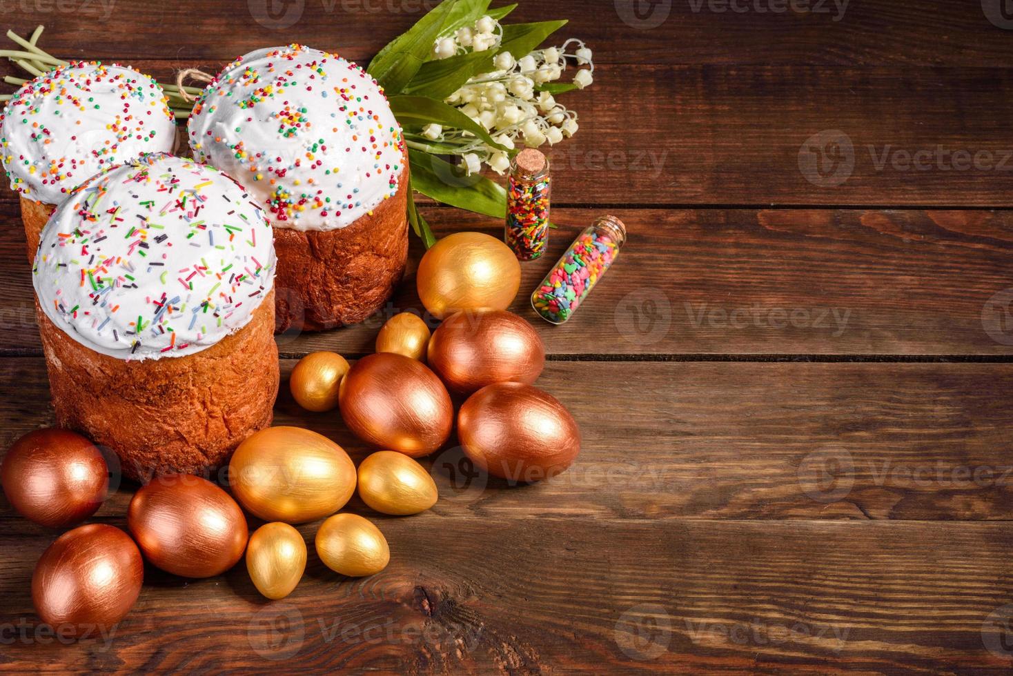 Huevos de pascua de oro y bronce y pastel de pascua sobre un fondo oscuro foto