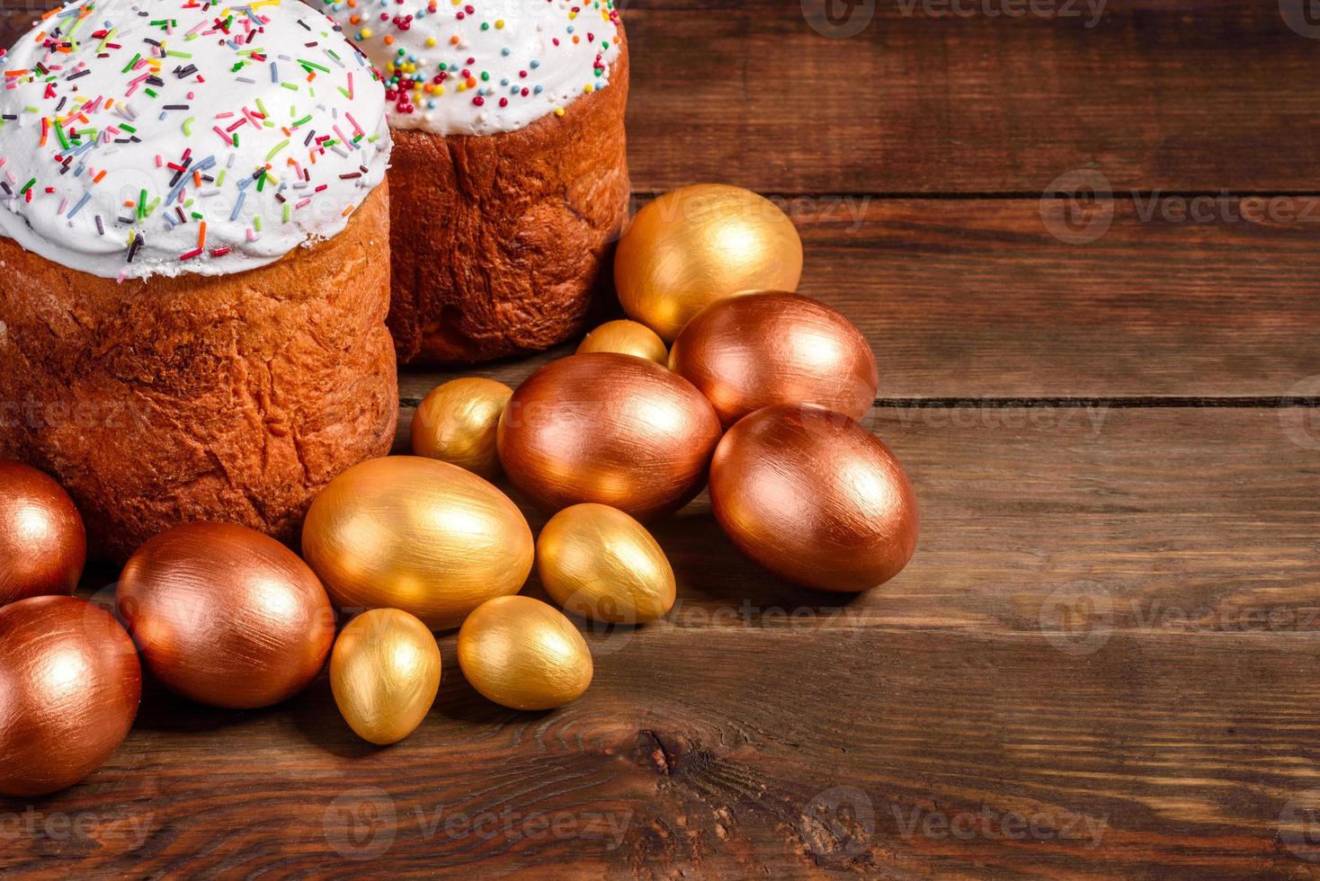 Huevos de pascua de oro y bronce y pastel de pascua sobre un fondo oscuro foto