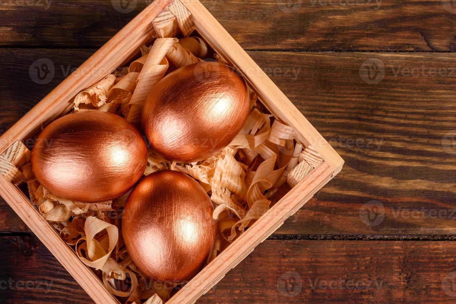 Huevos de Pascua en caja de madera de regalo sobre fondo de madera oscura. foto