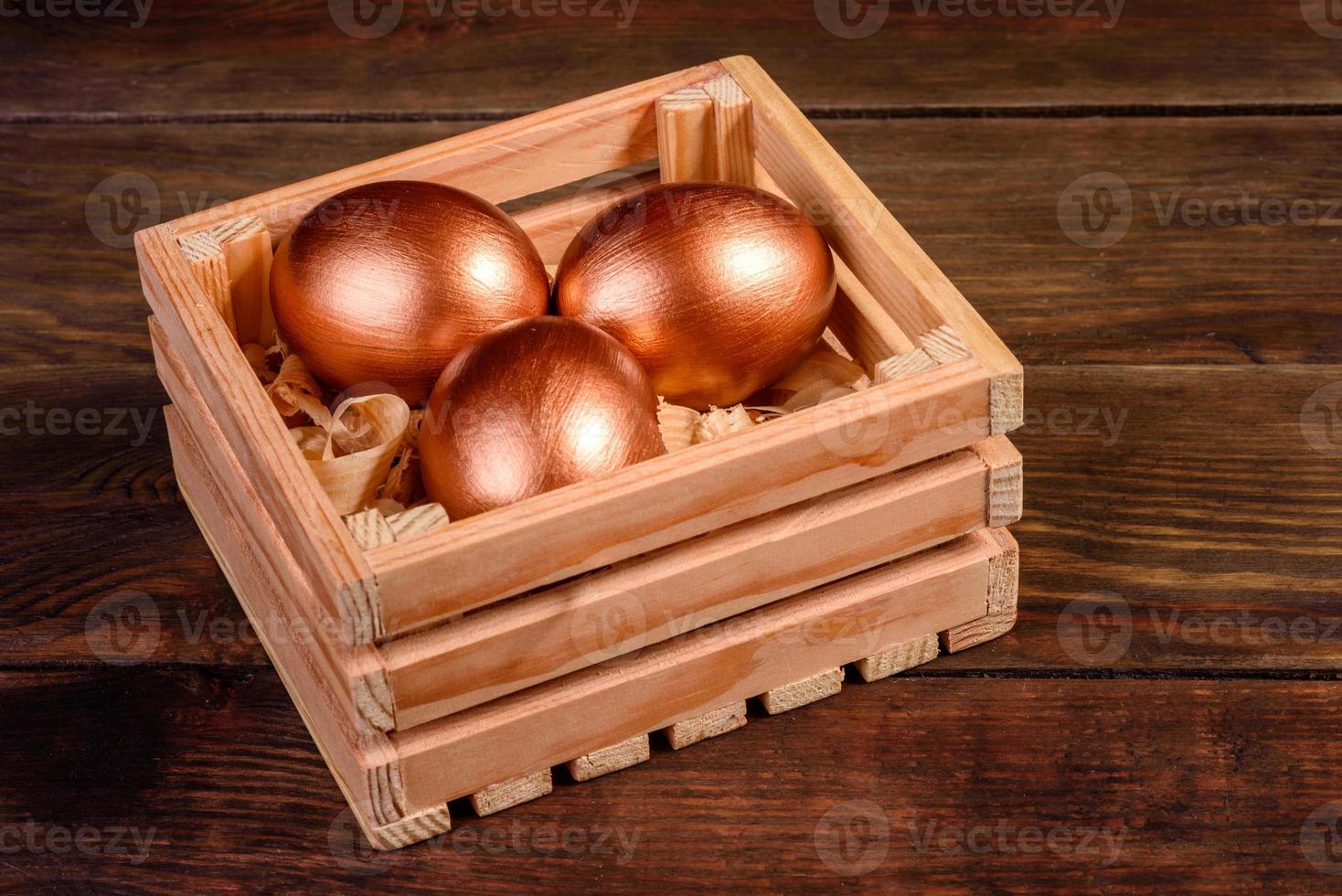 Easter eggs in gift wooden box on dark wooden background photo