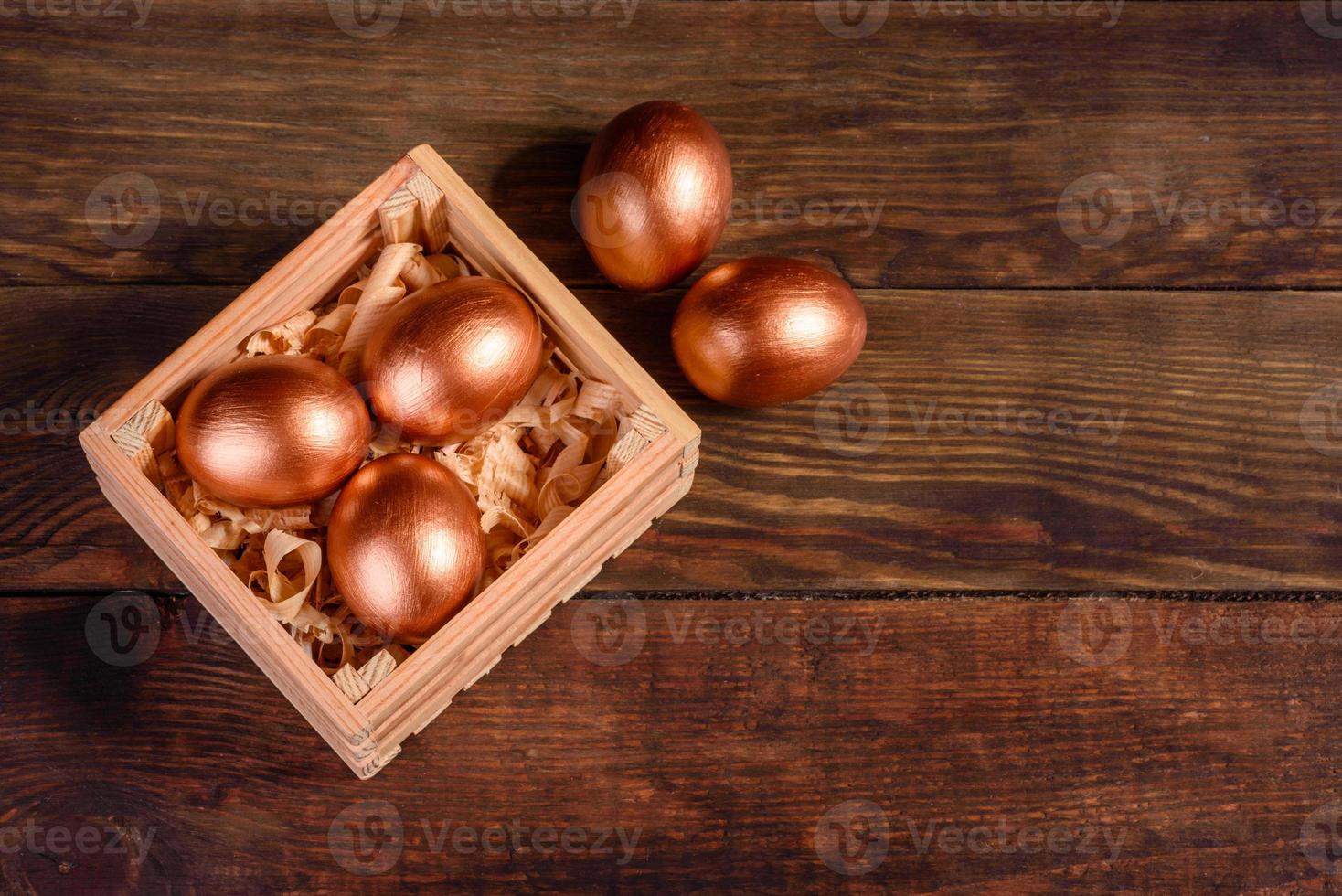 Huevos de Pascua en caja de madera de regalo sobre fondo de madera oscura. foto