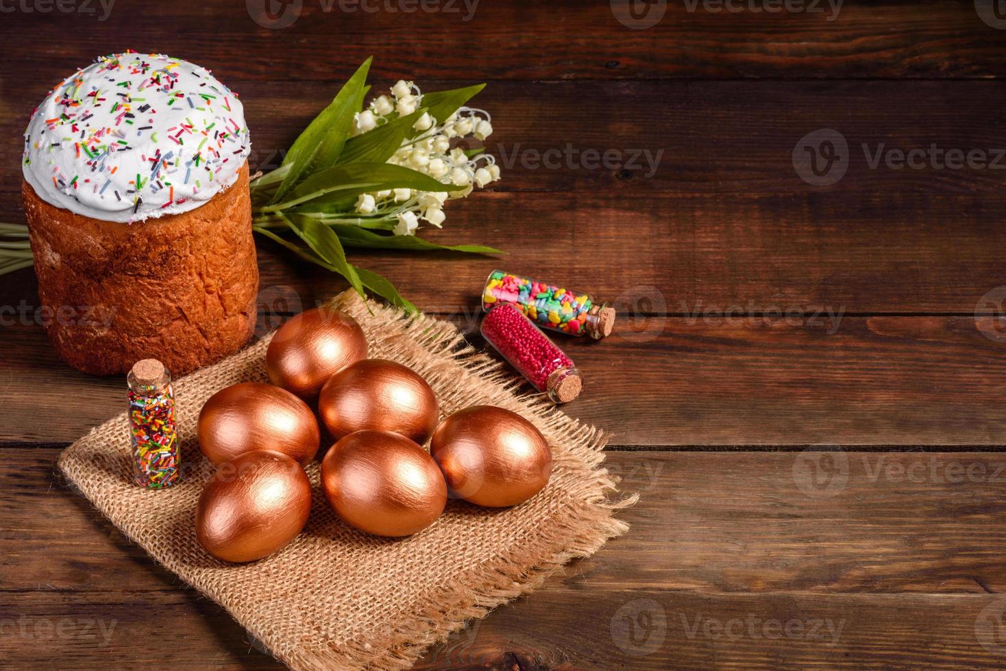 Huevos de pascua de oro y bronce y pastel de pascua sobre un fondo oscuro foto