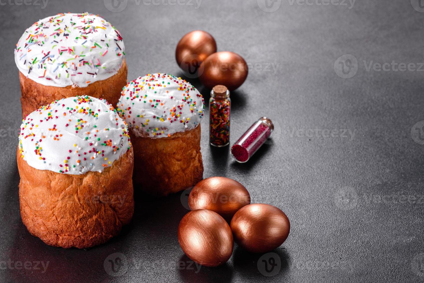 Huevos de pascua de oro y bronce y pastel de pascua sobre un fondo oscuro foto