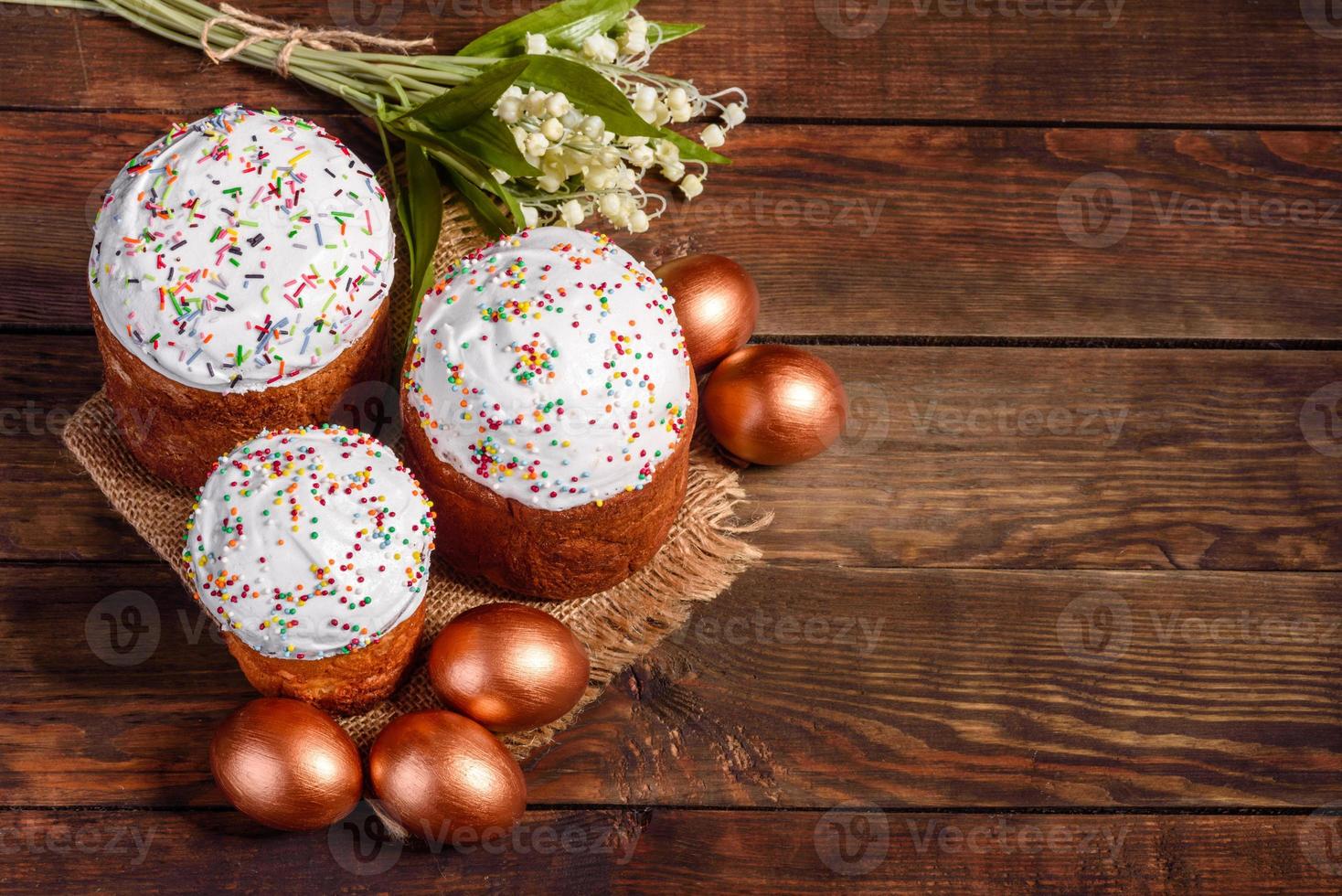 Huevos de pascua de oro y bronce y pastel de pascua sobre un fondo oscuro foto