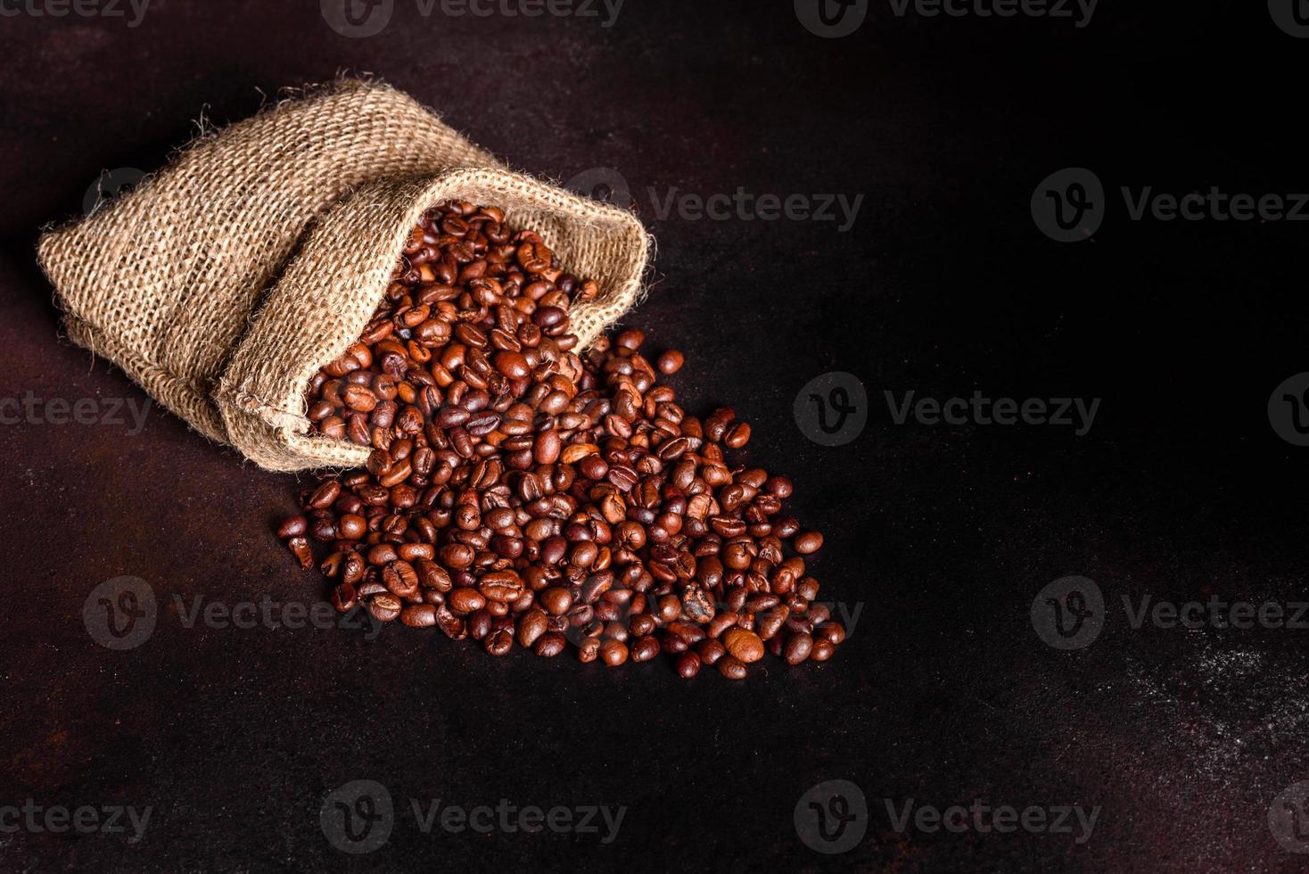 Granos de café recién tostado de cerca contra un fondo oscuro foto