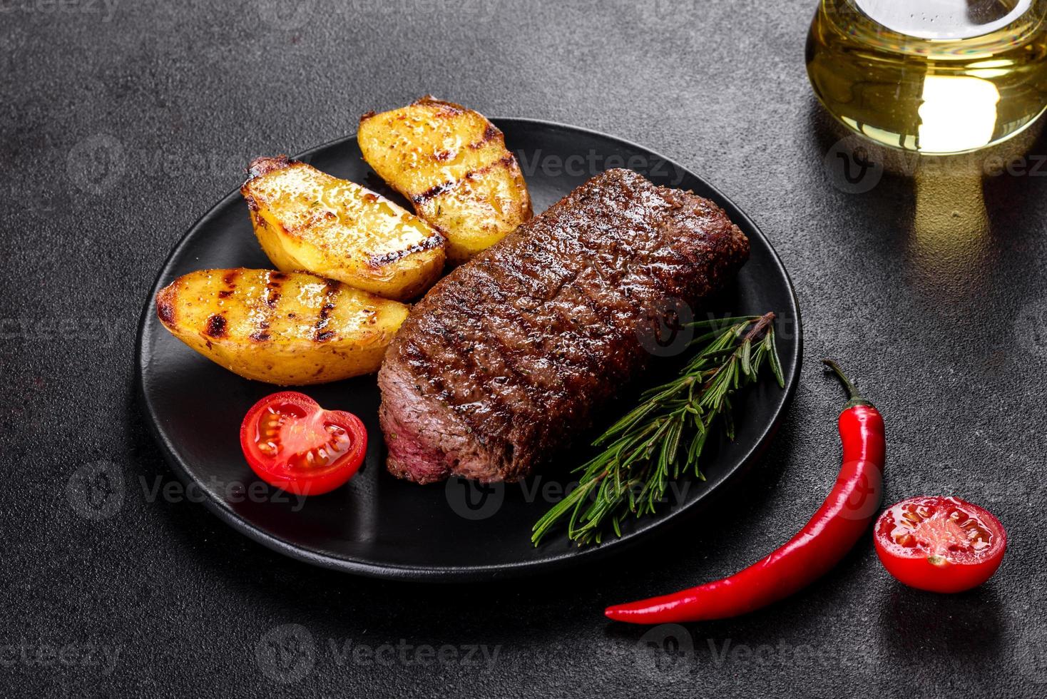 Ribeye steak with potatoes, onions and cherry tomatoes photo