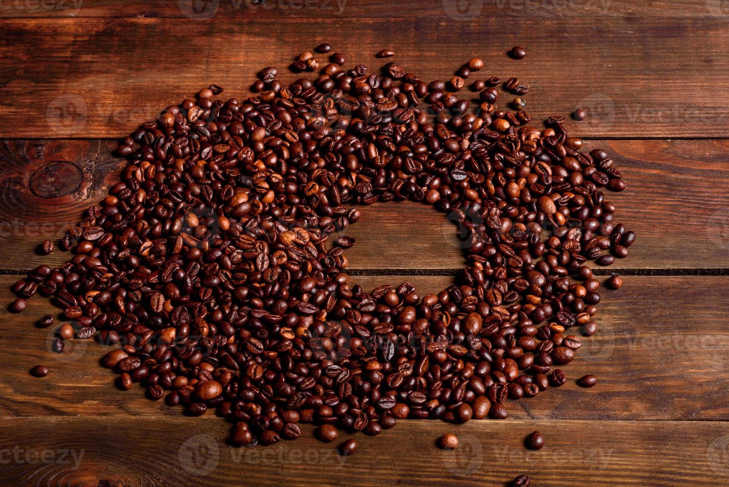 Granos de café recién tostado de cerca contra un fondo oscuro foto