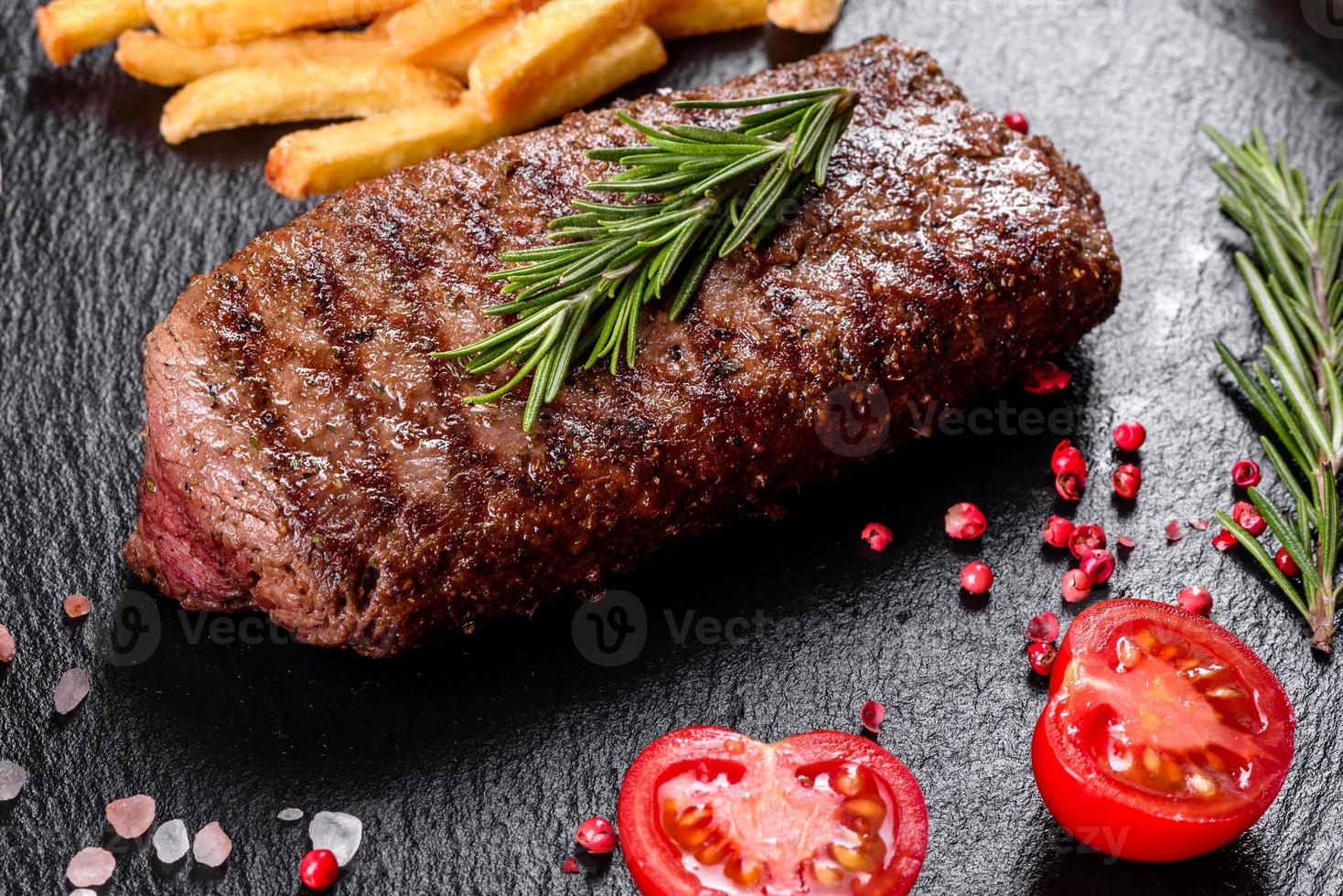 chuletón con patatas, cebollas y tomates cherry foto