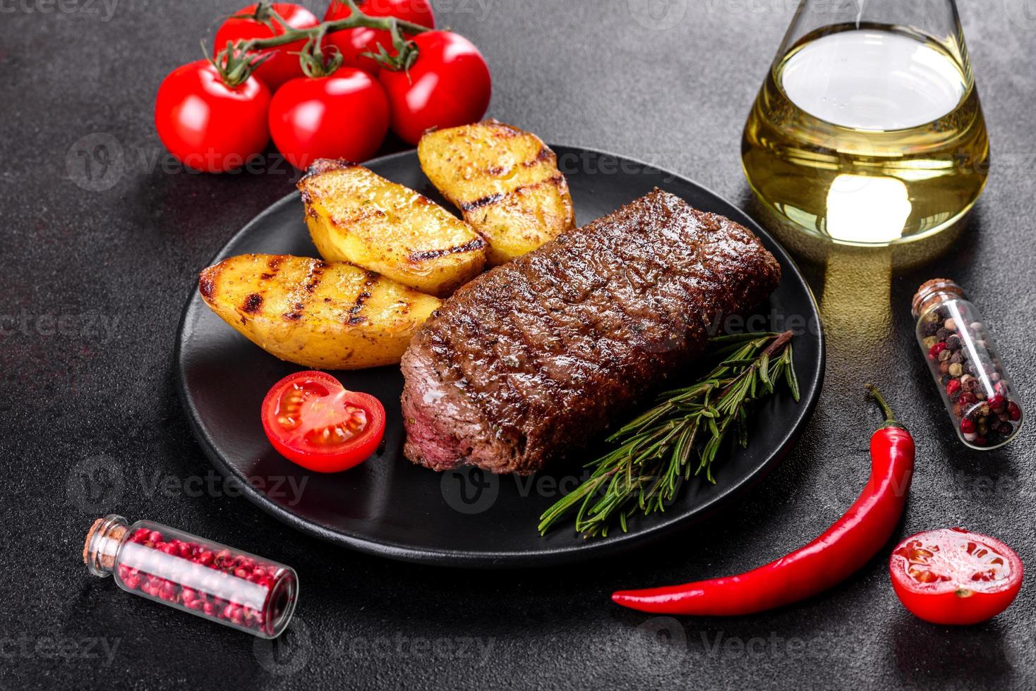 chuletón con patatas, cebollas y tomates cherry foto