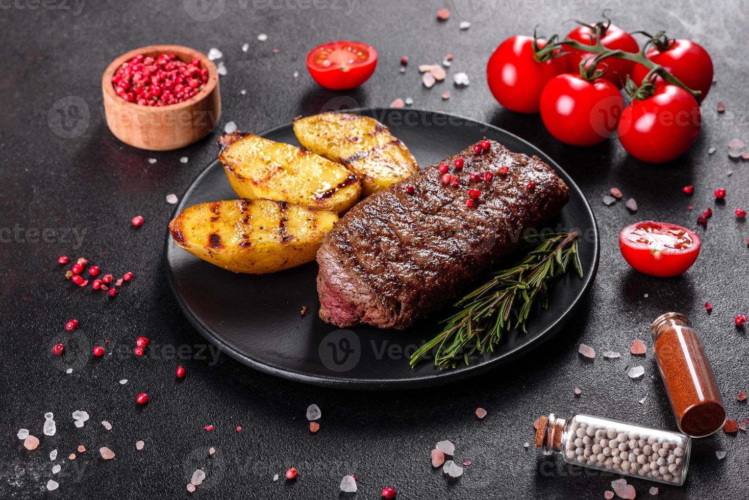 Ribeye steak with potatoes, onions and cherry tomatoes photo