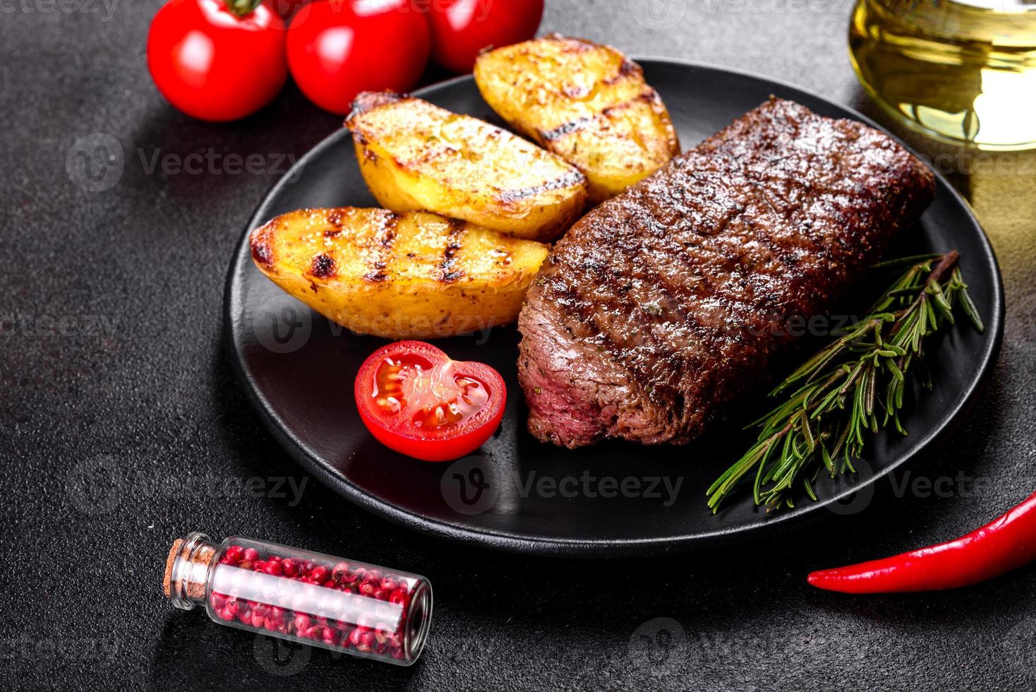 chuletón con patatas, cebollas y tomates cherry foto