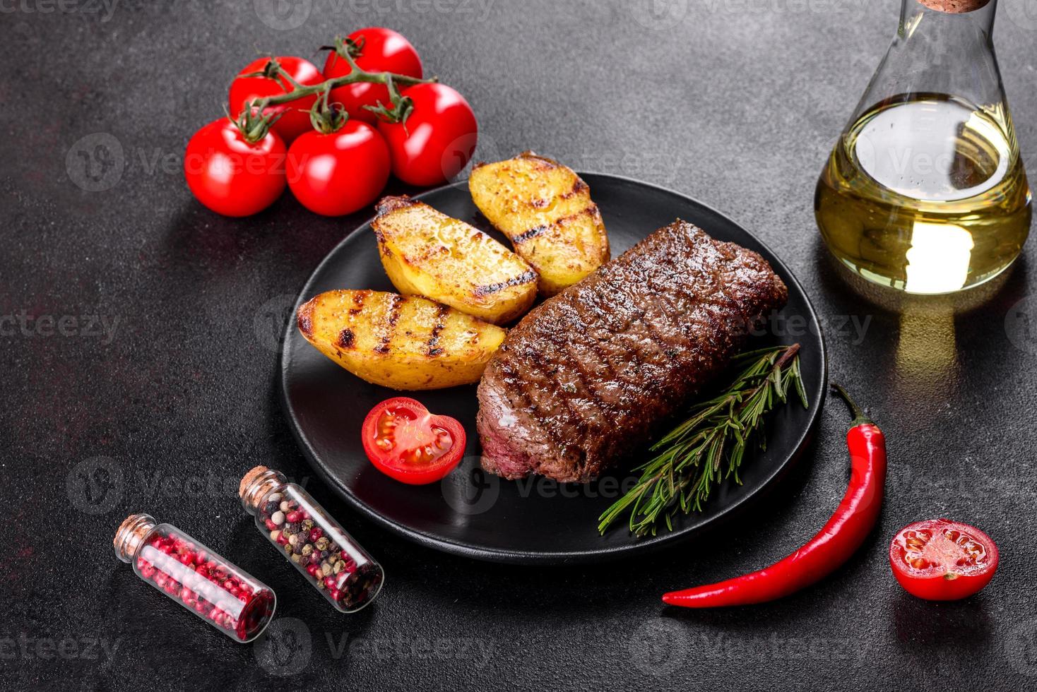 Ribeye steak with potatoes, onions and cherry tomatoes photo