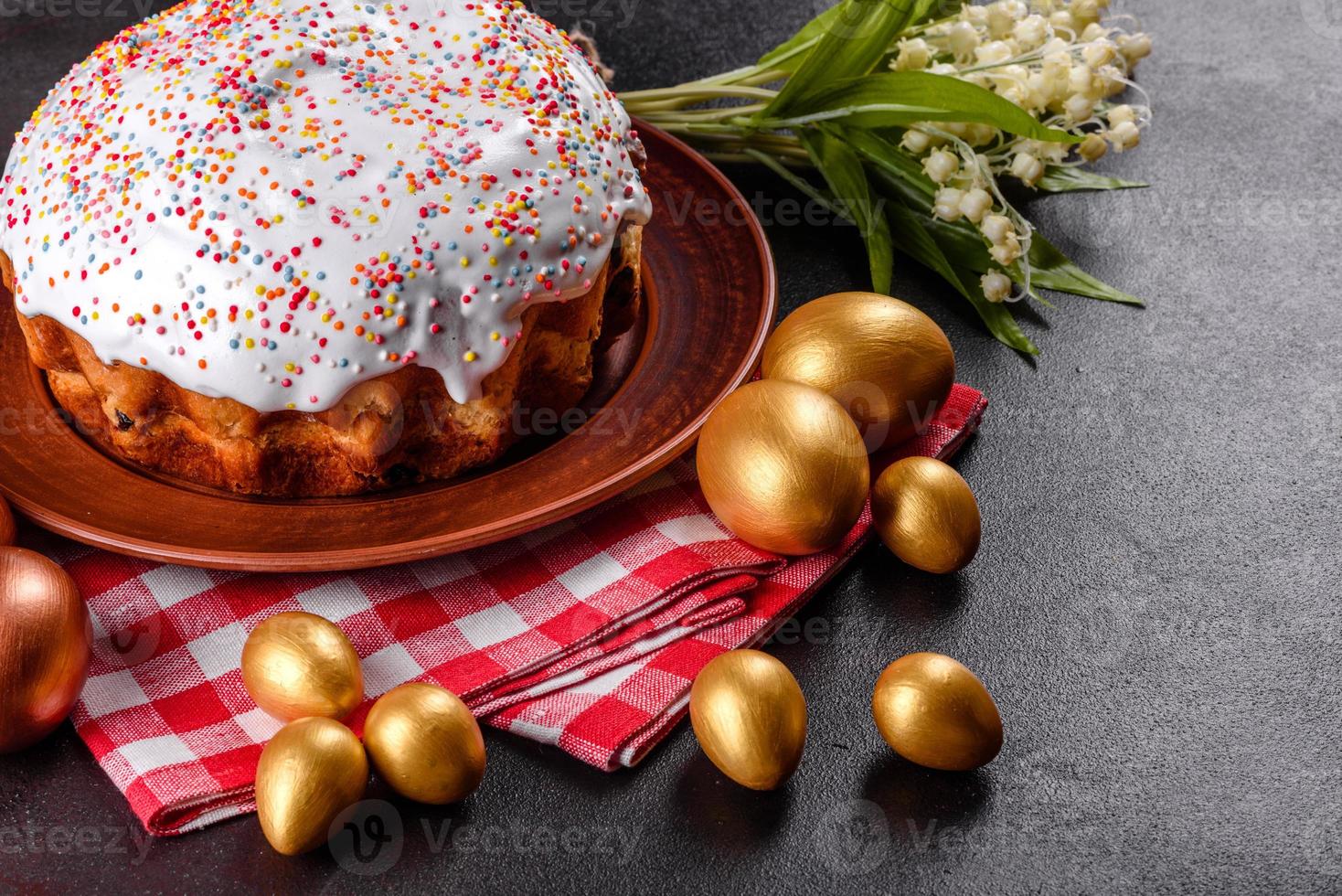 Huevos de pascua de oro y bronce y pastel de pascua sobre un fondo oscuro foto