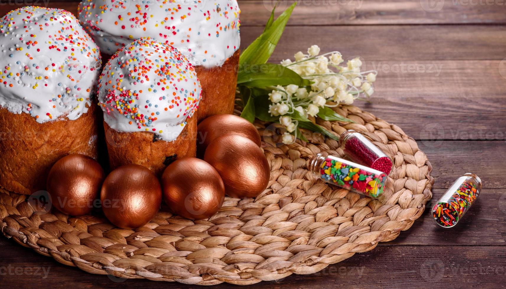 Huevos de pascua de oro y bronce y pastel de pascua sobre un fondo oscuro foto