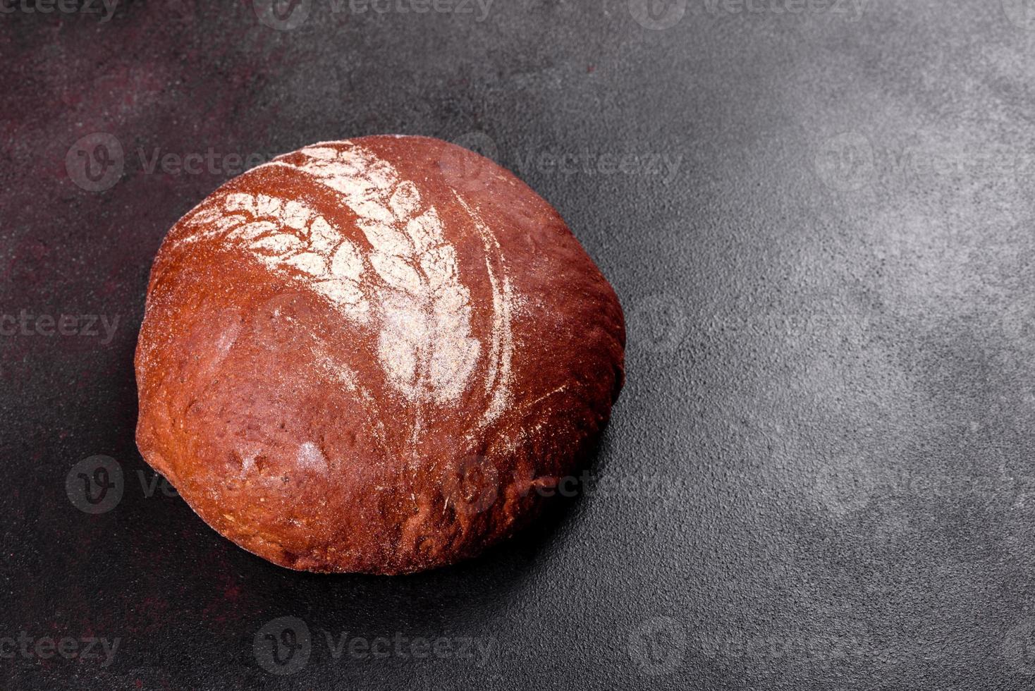 Fresh baked brown bread on a brown concrete background photo