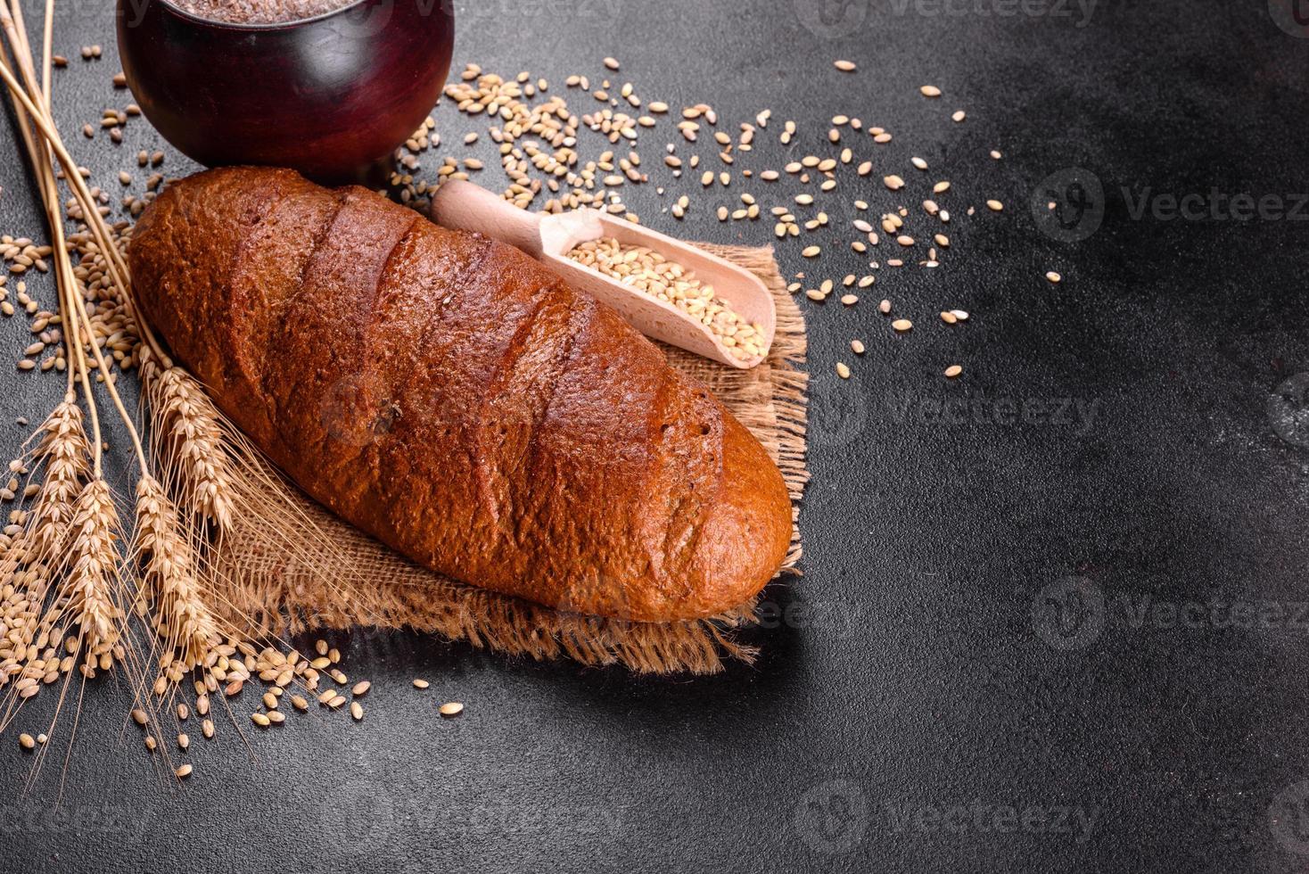 Pan integral recién horneado sobre un fondo de hormigón marrón foto