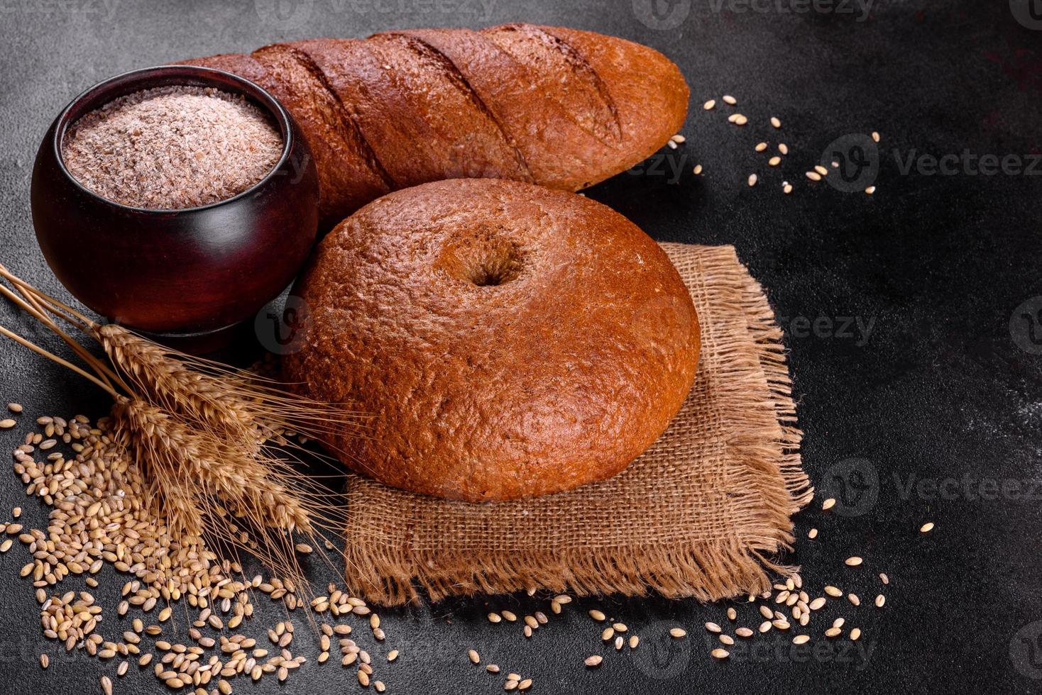 Fresh baked brown bread on a brown concrete background photo