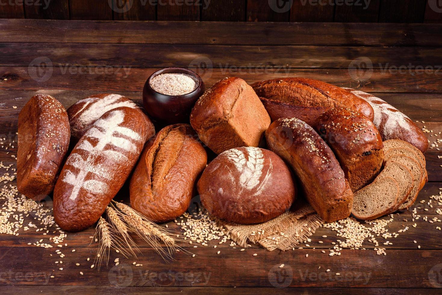 Fresh baked brown bread on a brown wooden background photo