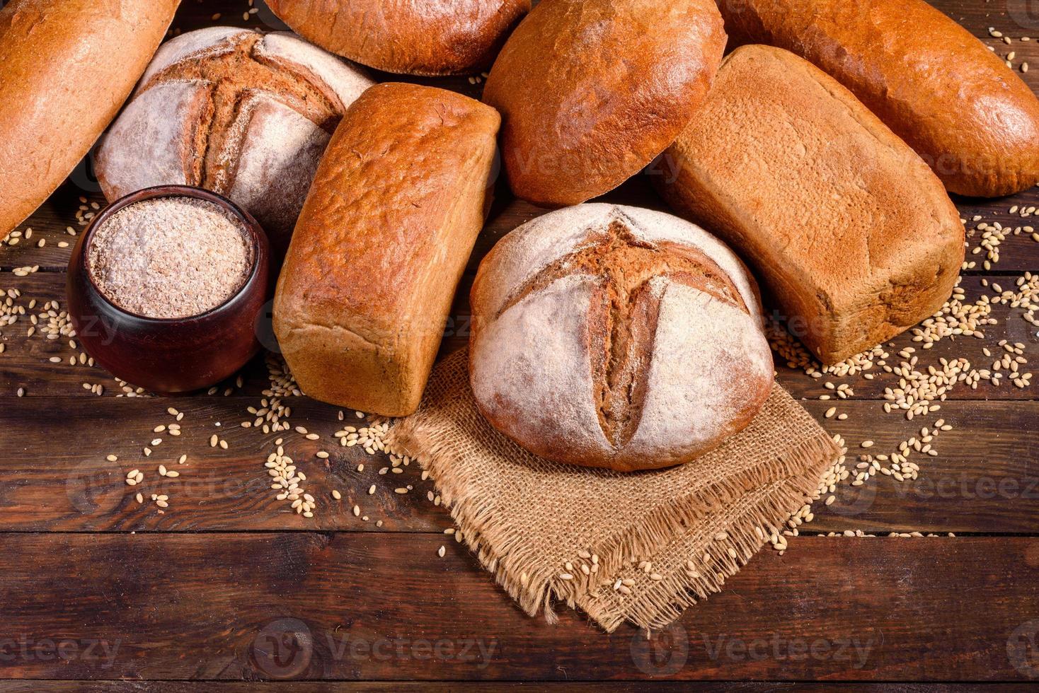 Fresh baked brown bread on a brown wooden background photo
