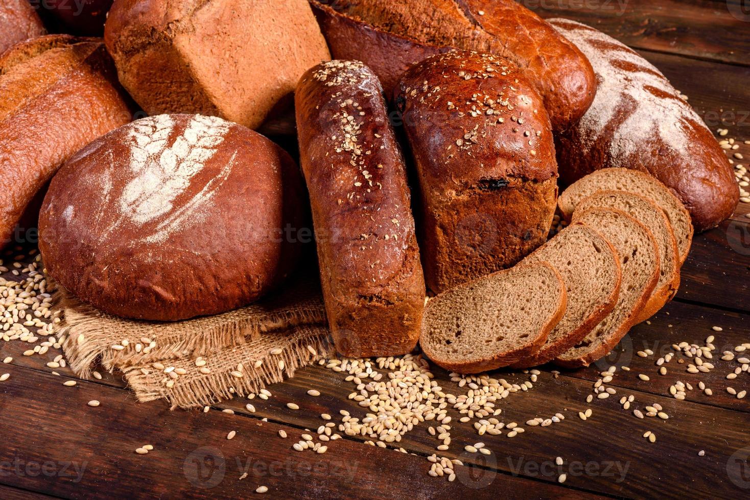 Fresh baked brown bread on a brown wooden background photo