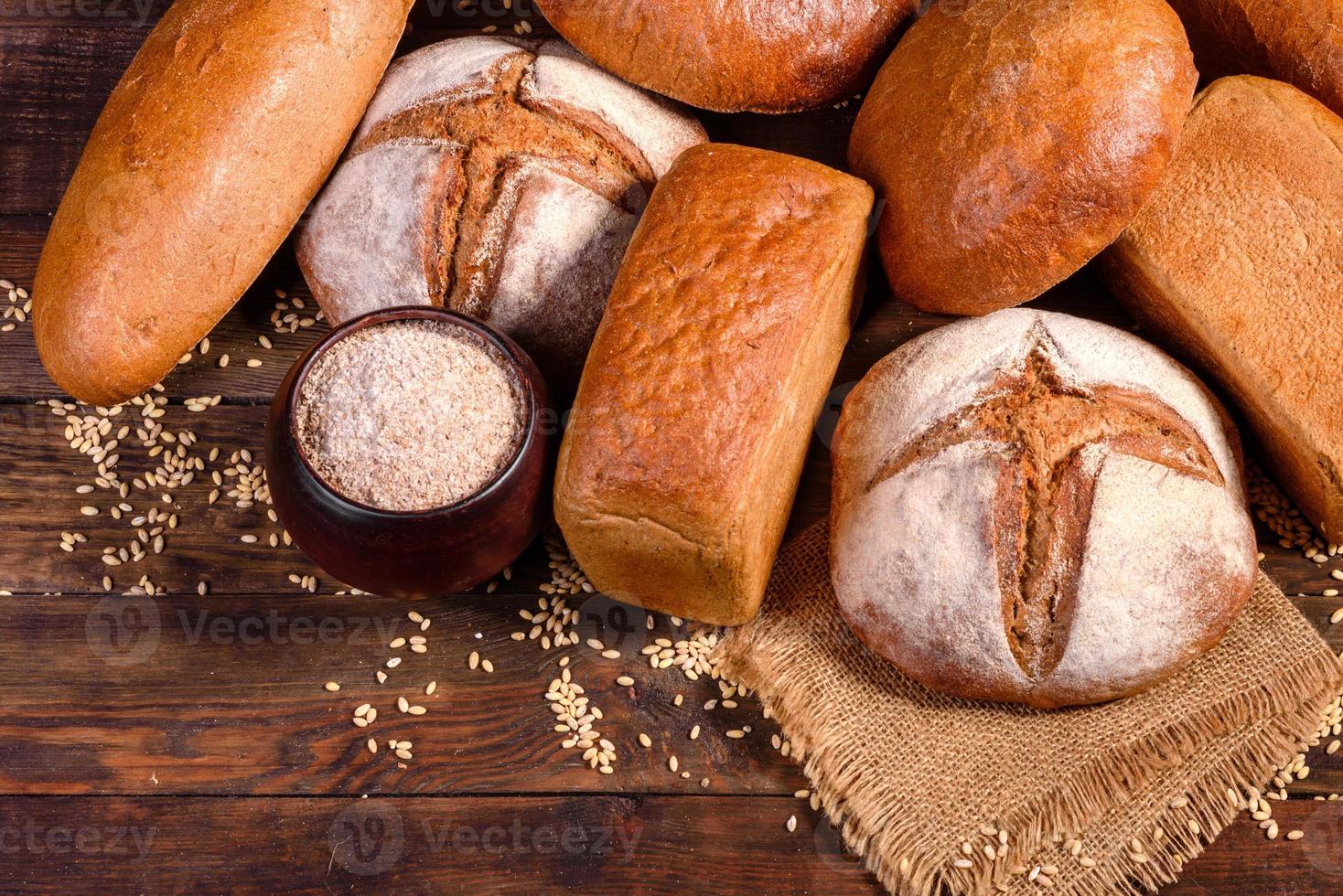 Fresh baked brown bread on a brown wooden background photo