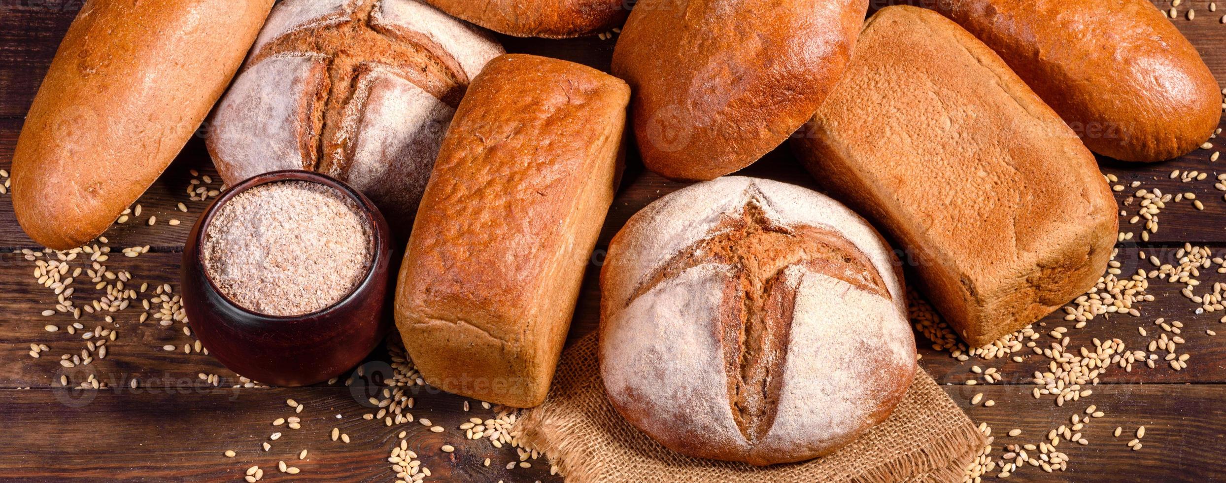 Fresh baked brown bread on a brown wooden background photo