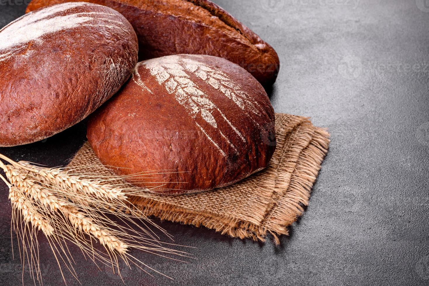 Fresh baked brown bread on a brown concrete background photo