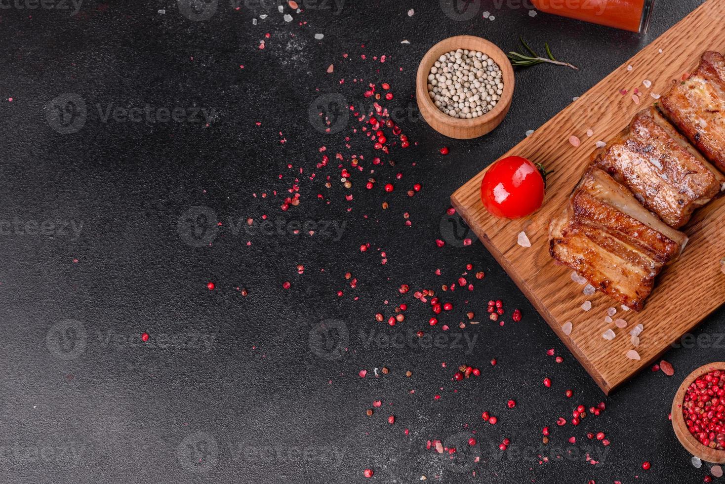 Fried ribs with rosemary, onion, sauce on a concrete background photo