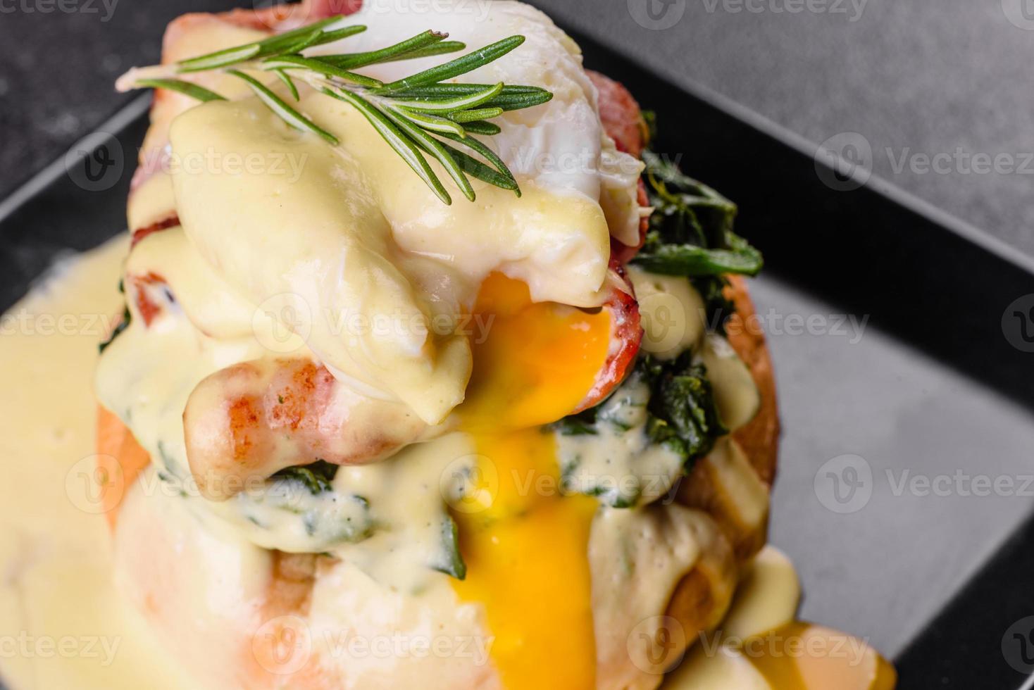 Eggs benedict or eggs florentine on a black plate in the cafe photo
