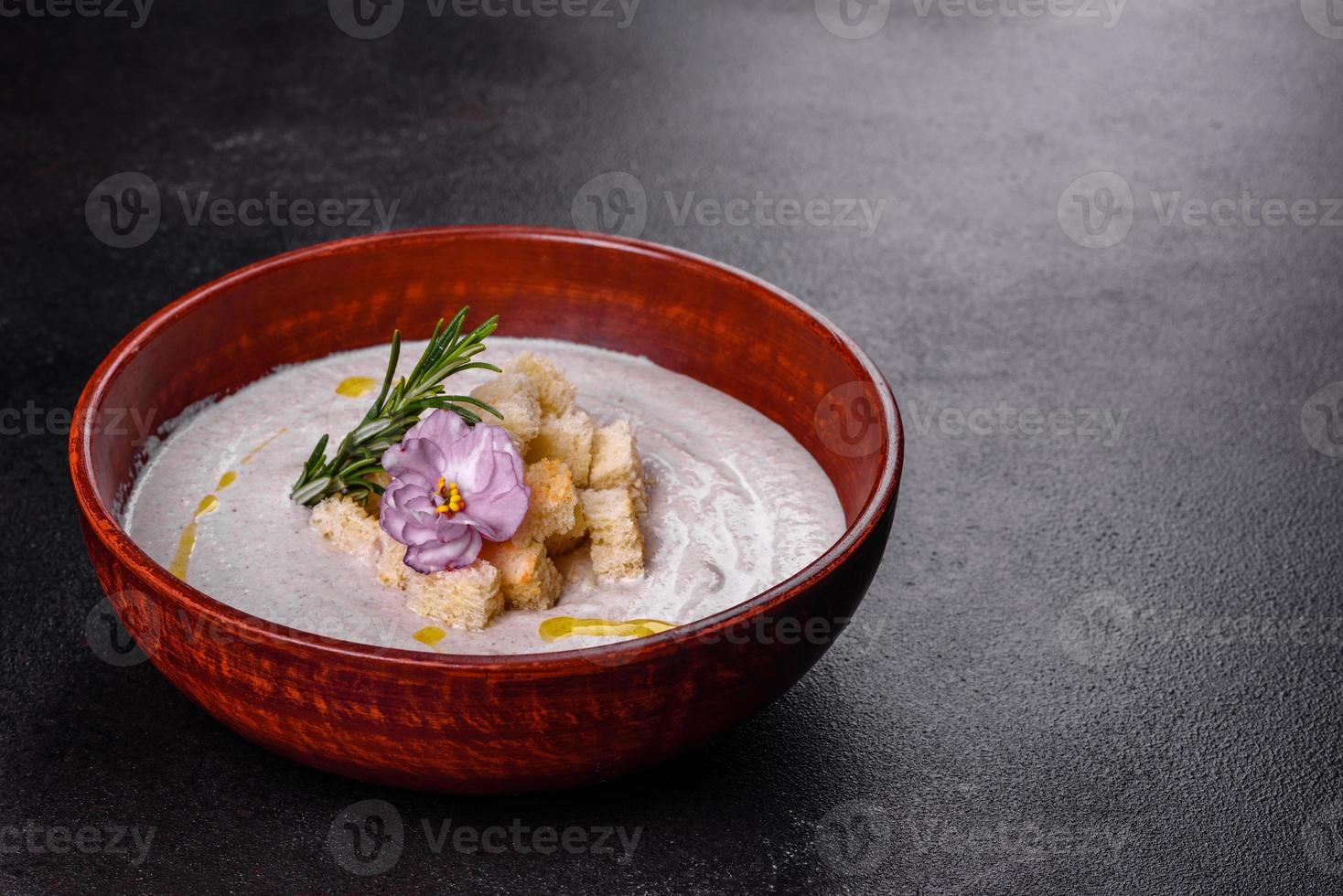 Delicious beautiful mushroom soup in a brown plate with a wooden spoon photo