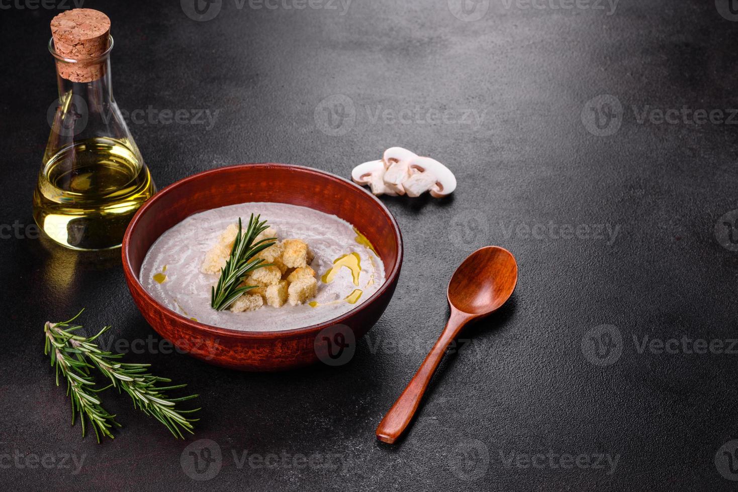 Delicious beautiful mushroom soup in a brown plate with a wooden spoon photo