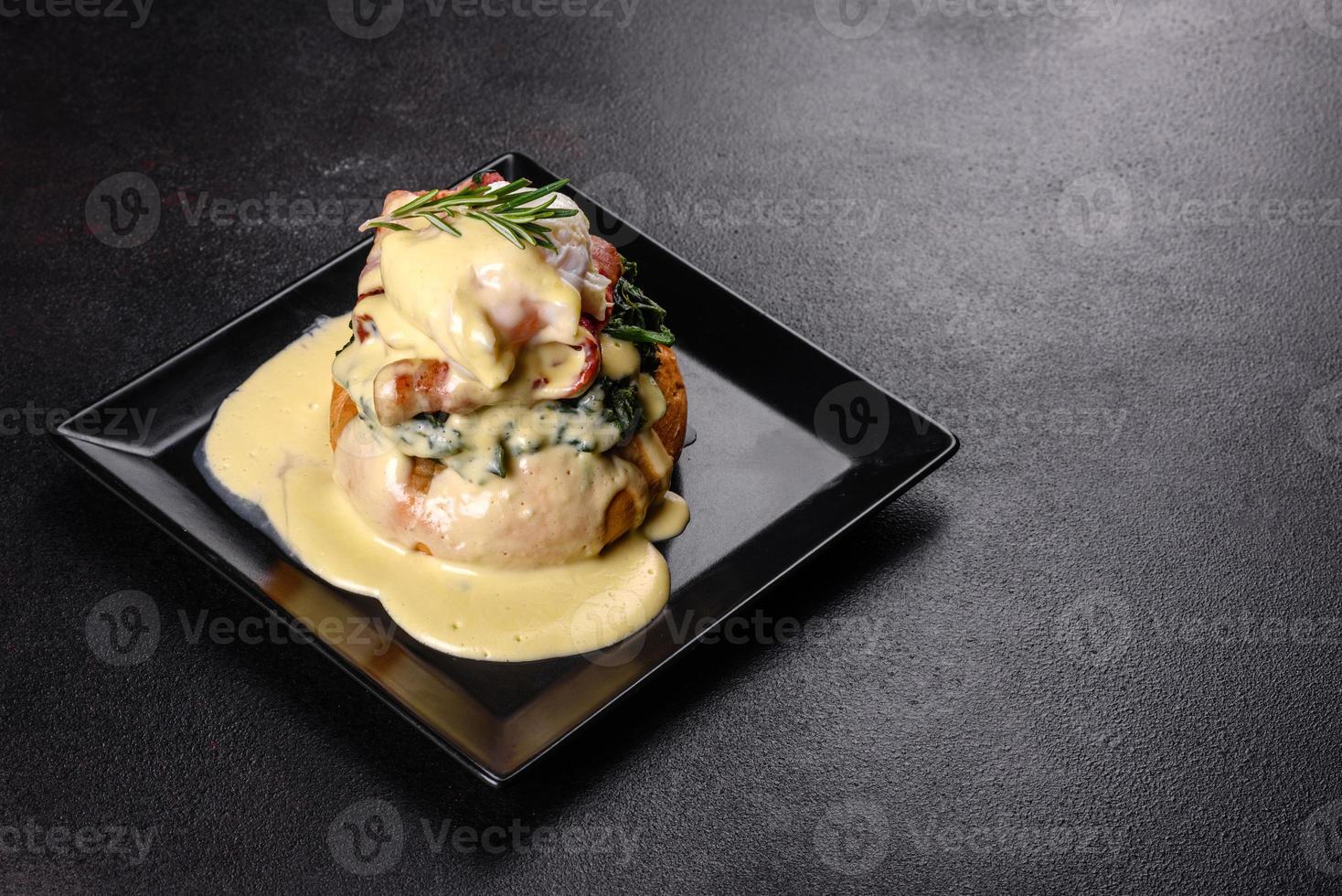 Eggs benedict or eggs florentine on a black plate in the cafe photo