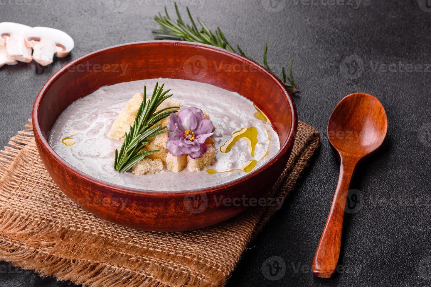 Delicious beautiful mushroom soup in a brown plate with a wooden spoon photo