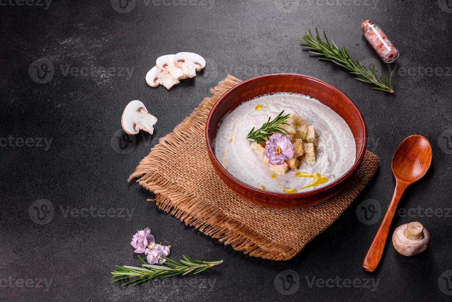 deliciosa sopa de hongos hermosa en un plato marrón con una cuchara de madera foto