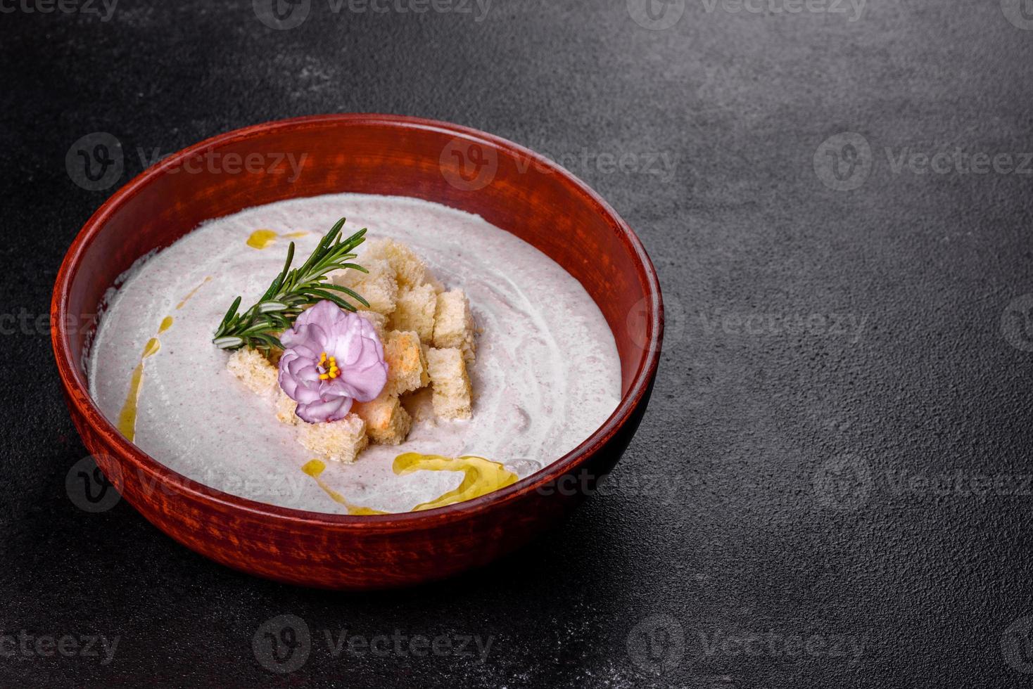 deliciosa sopa de hongos hermosa en un plato marrón con una cuchara de madera foto