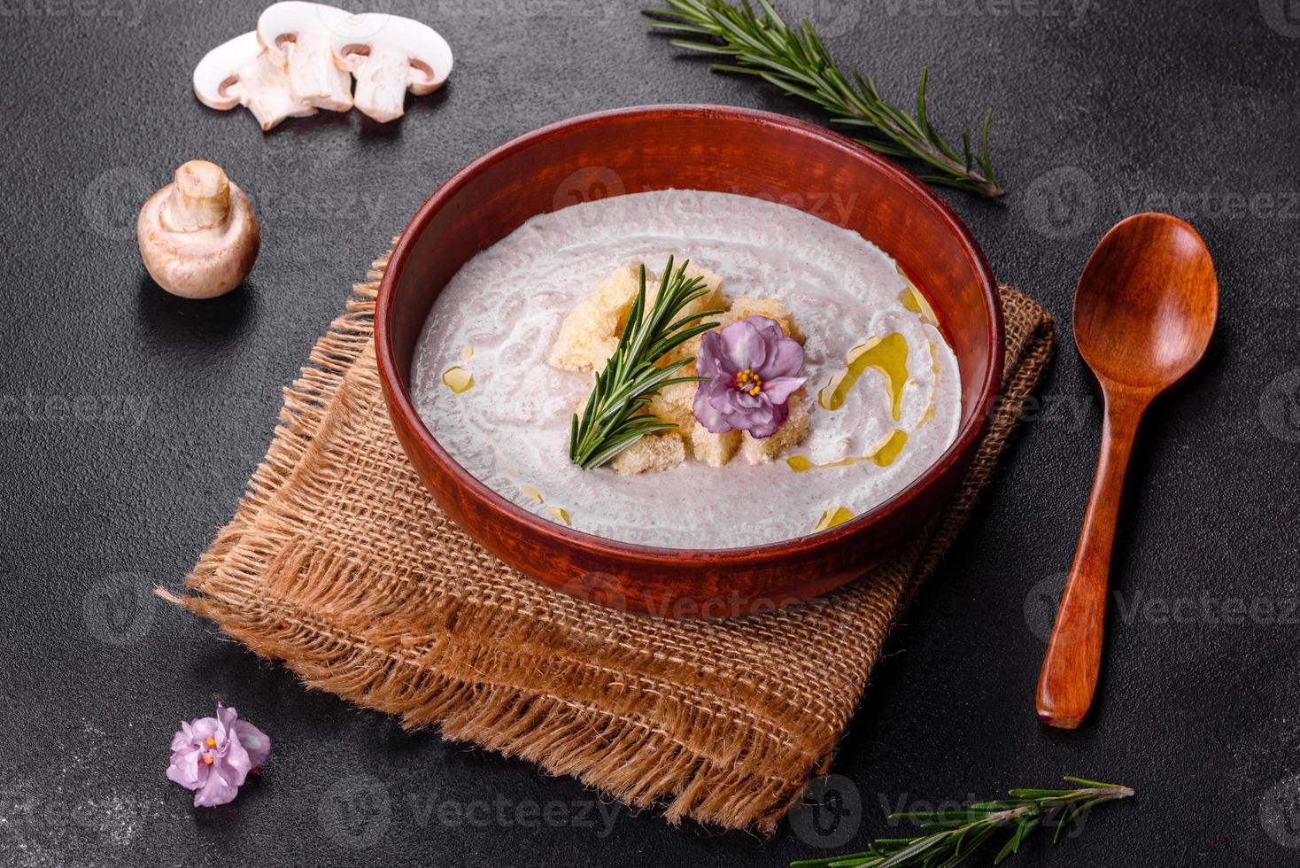 Delicious beautiful mushroom soup in a brown plate with a wooden spoon photo