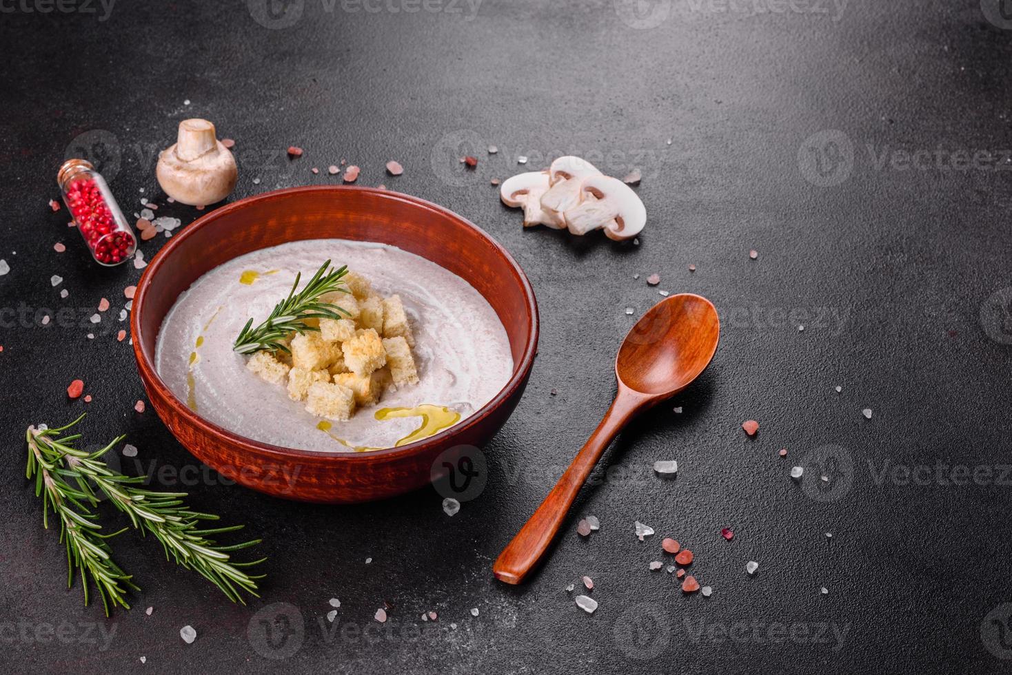 Delicious beautiful mushroom soup in a brown plate with a wooden spoon photo