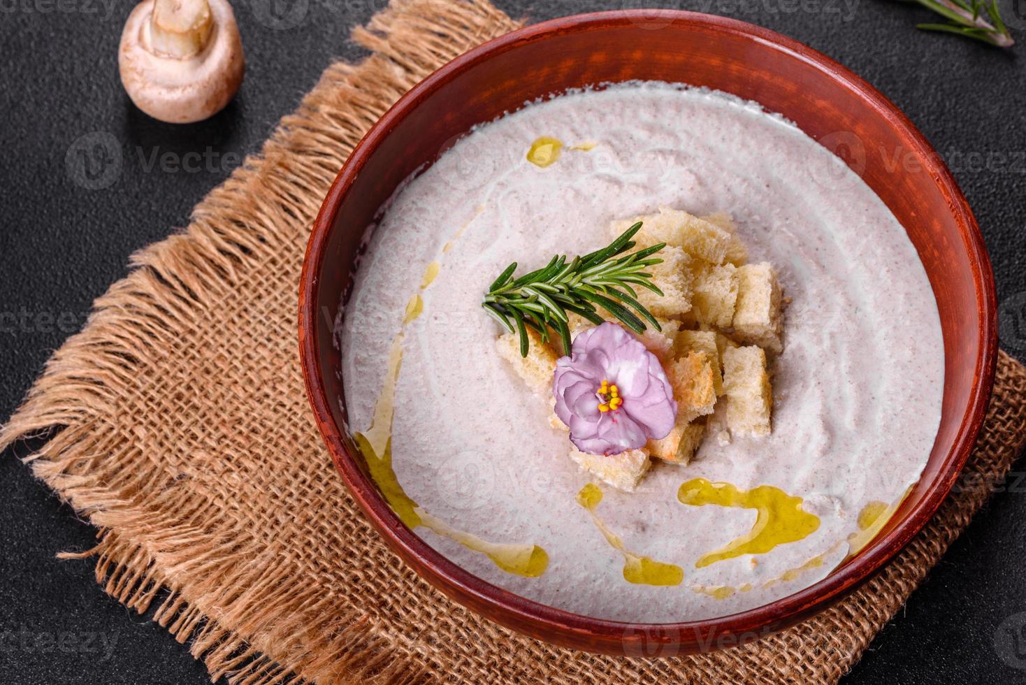 Delicious beautiful mushroom soup in a brown plate with a wooden spoon photo