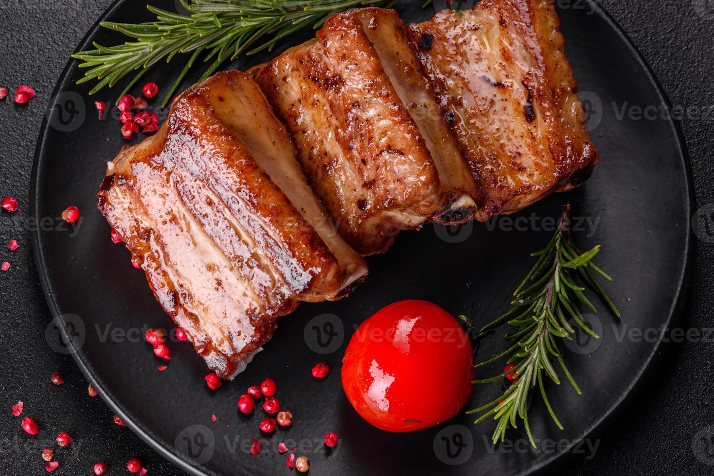 Costillas fritas con romero, cebolla, salsa sobre un fondo de hormigón foto