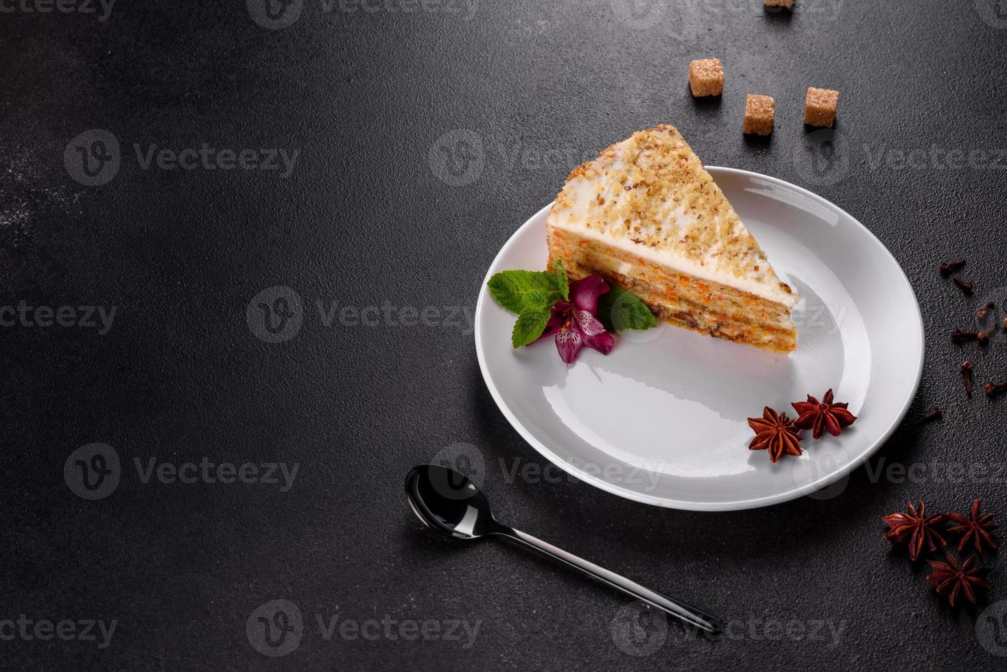 Fresh delicious carrot cake with cream on a dark background photo